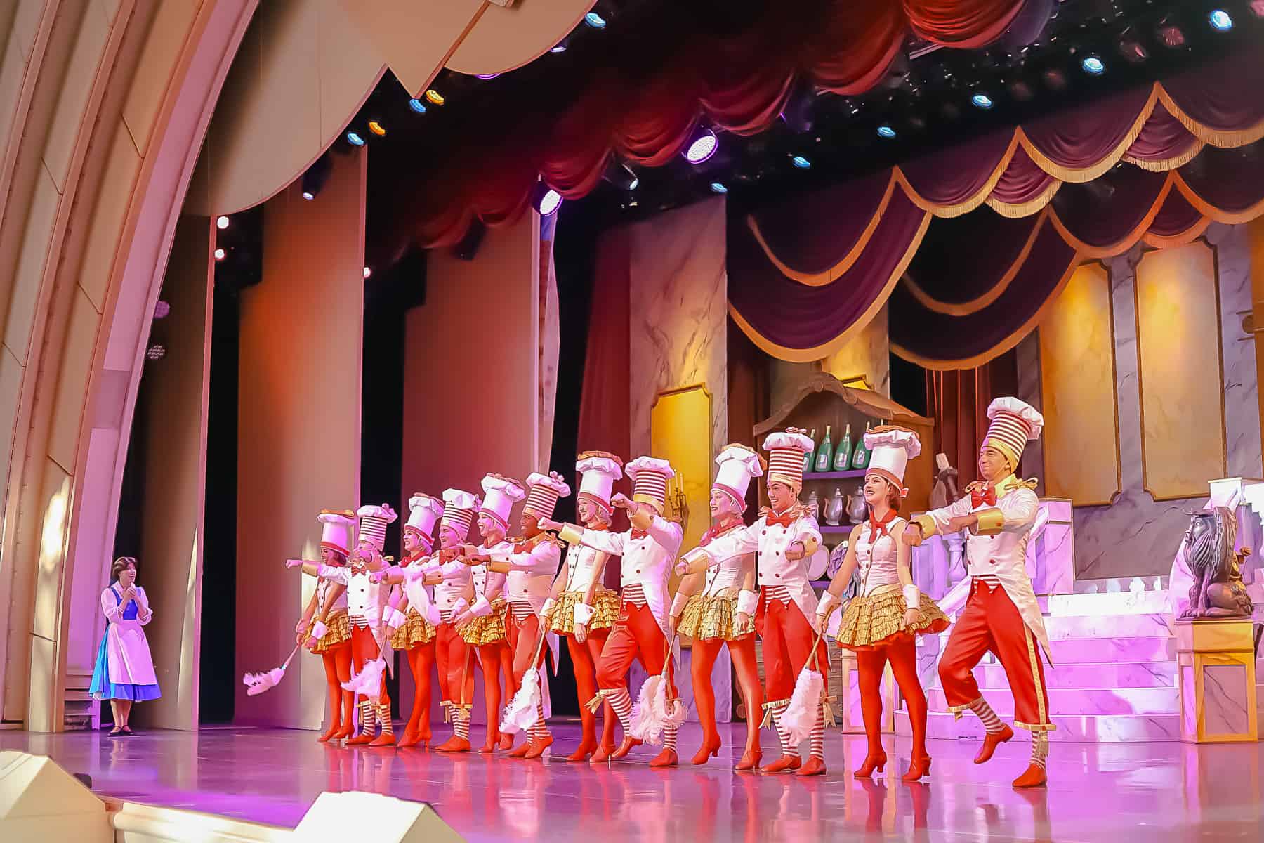 a line of dancers in red tights and striped chef hats 