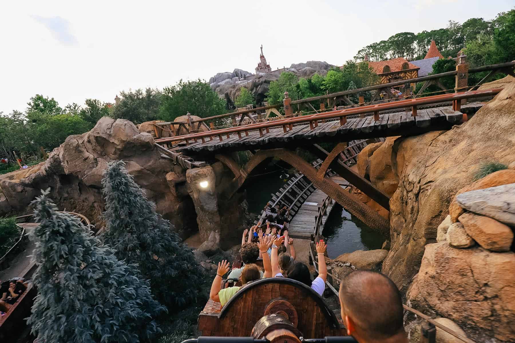 Guests with arms up as they race downhill after the mine scene with the Seven Dwarfs. 