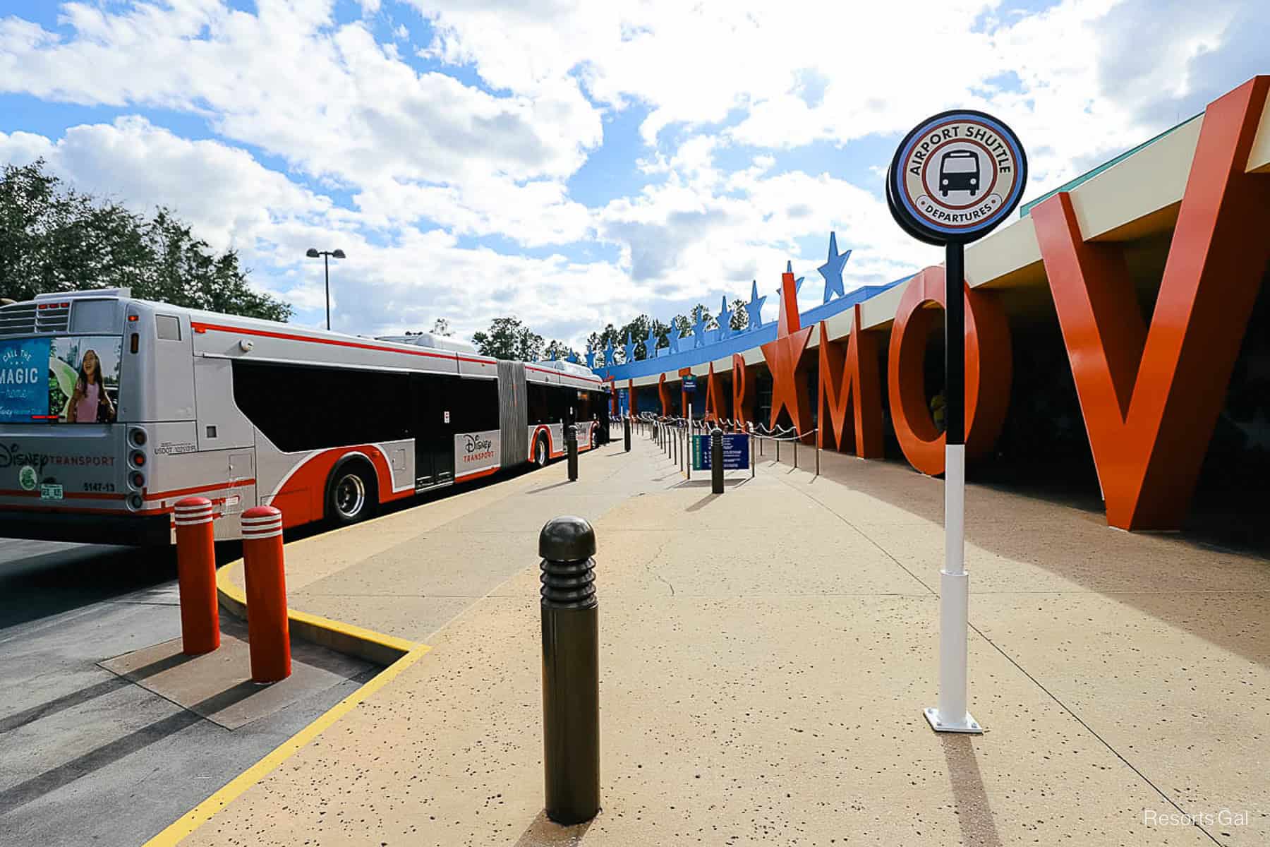 the bus stop with a sign that shows where to wait for the airport shuttle 