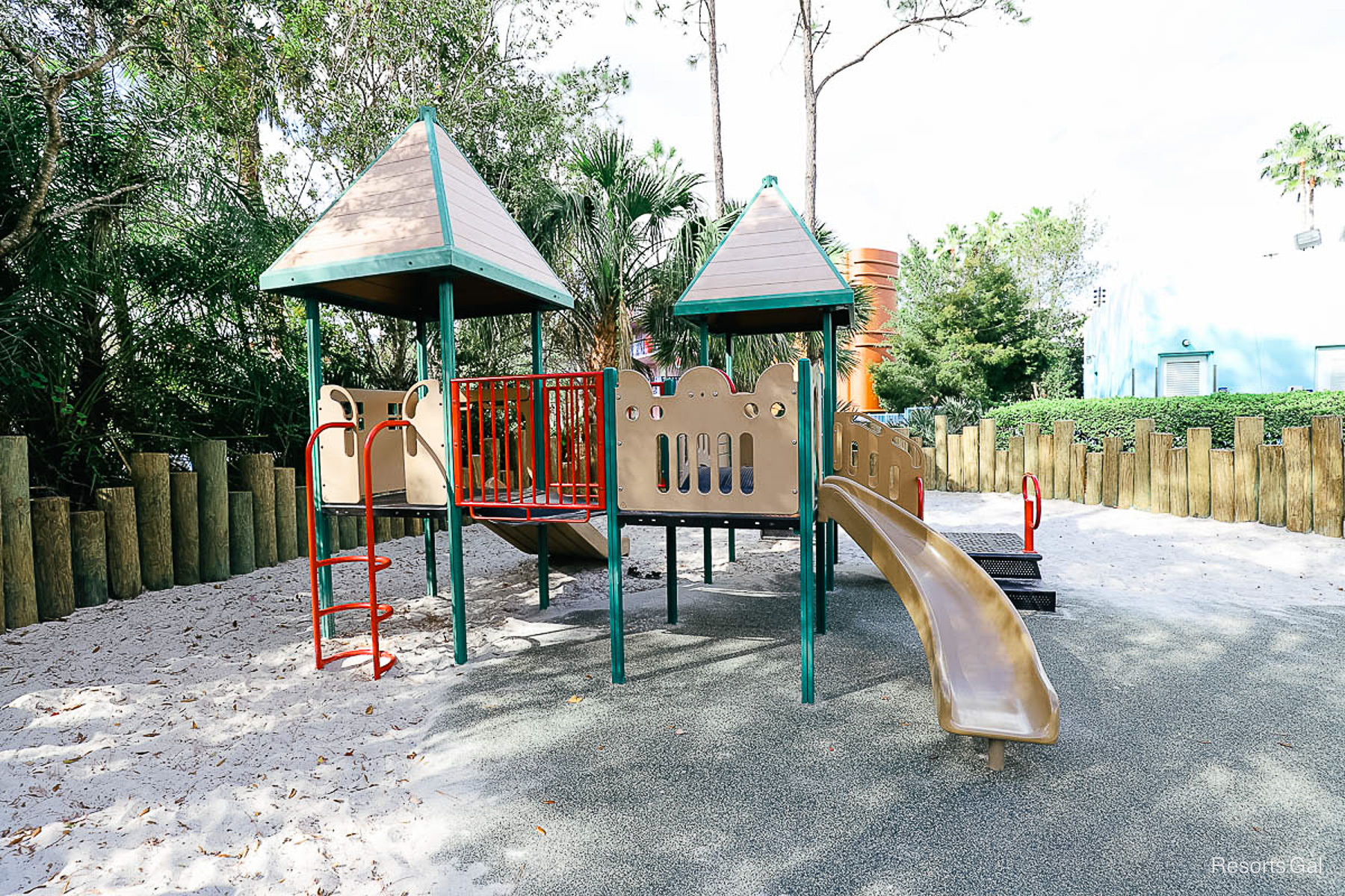 a side view of the playground with a slide 