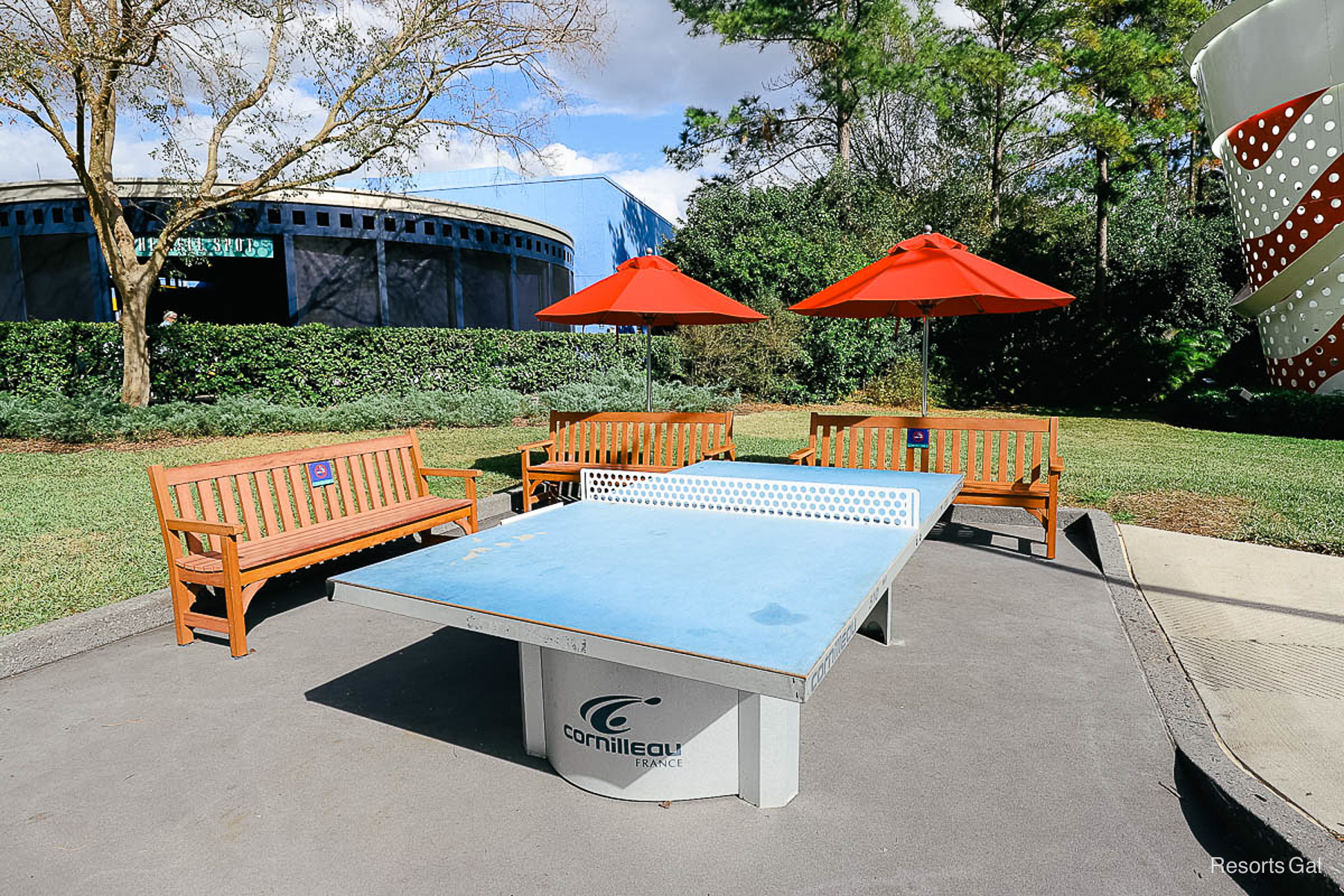 a ping pong table with brown benches sitting around it 