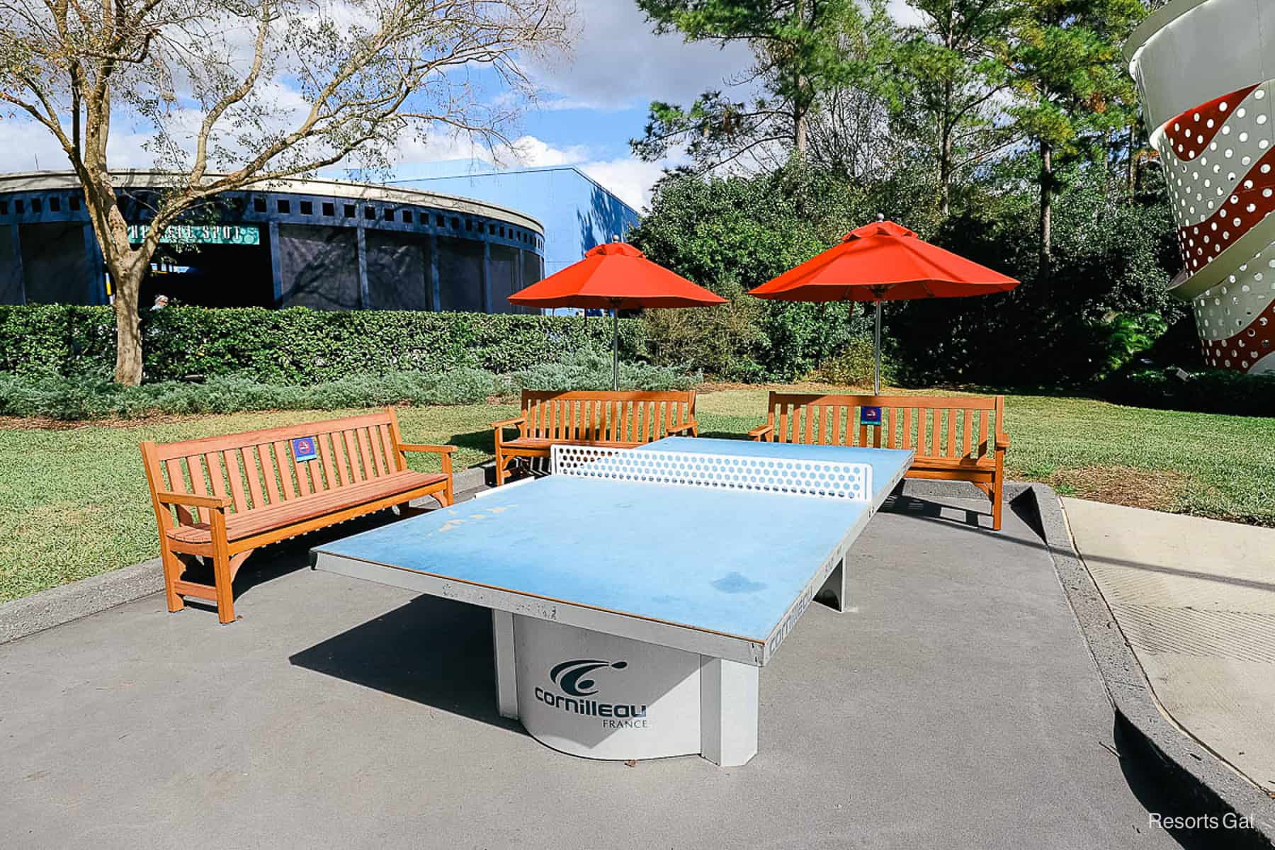 a ping pong table with brown benches sitting around it 