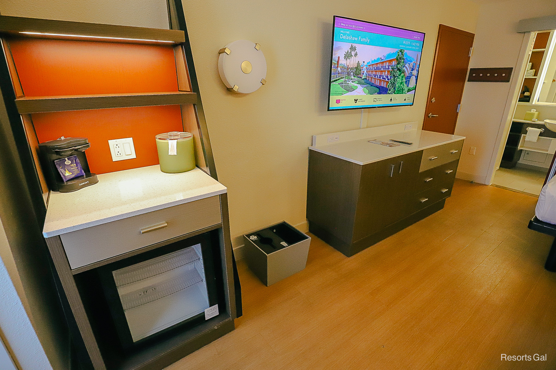 the storage shelf, beverage cooler, dresser, and television in the room 