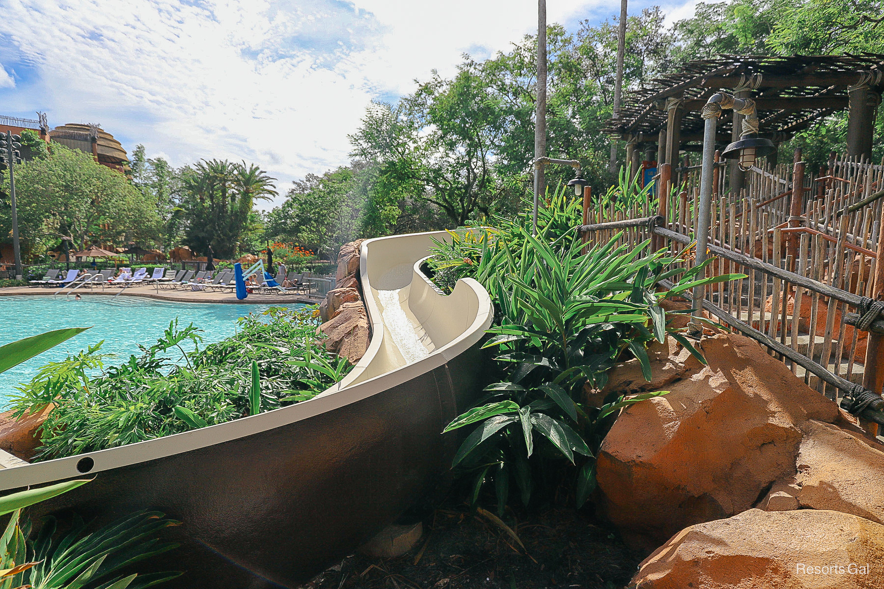 the gentle curve of the water slide sitting amongst rocks and landscaping 