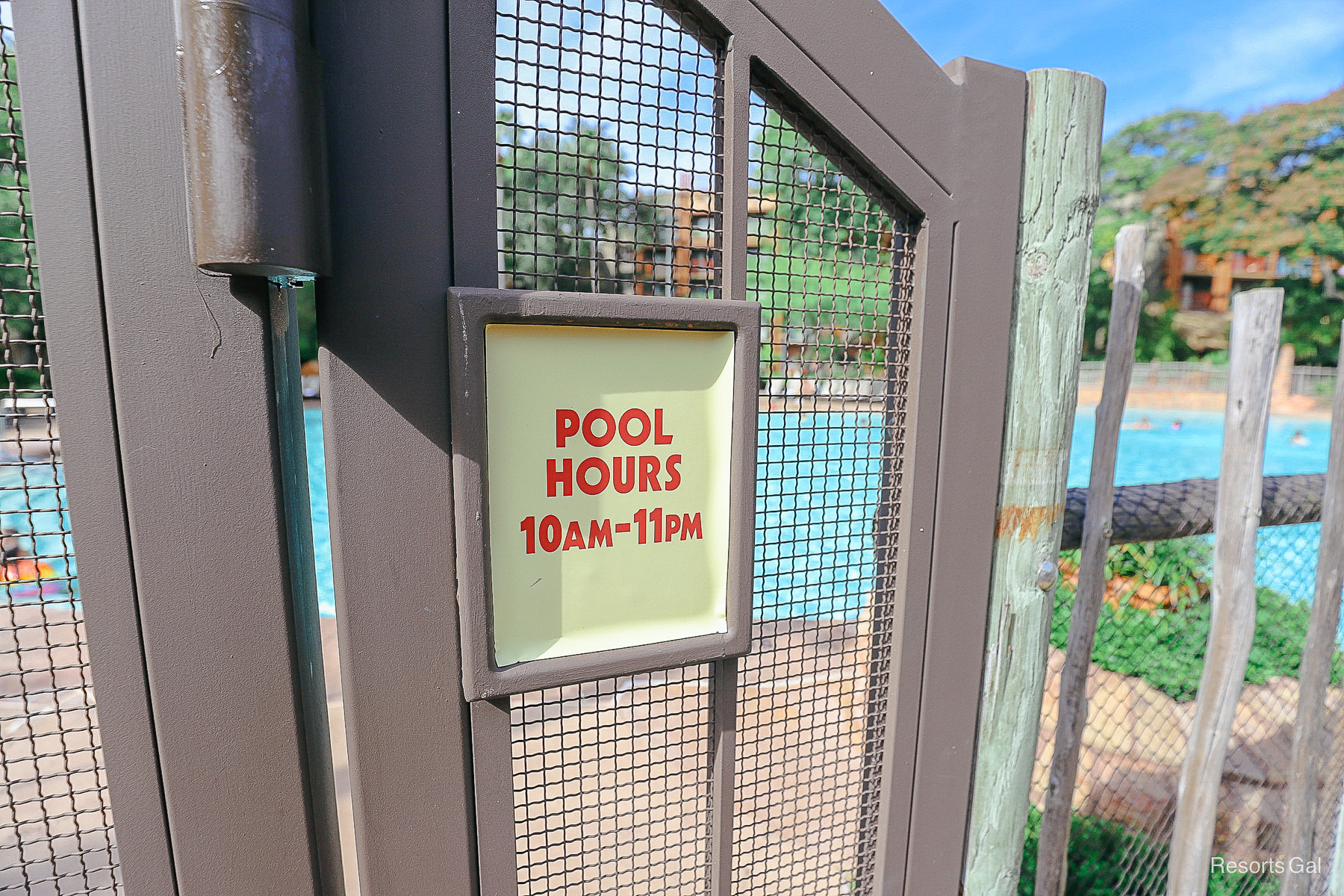a sign on the pool gate with the pools hours of operation 