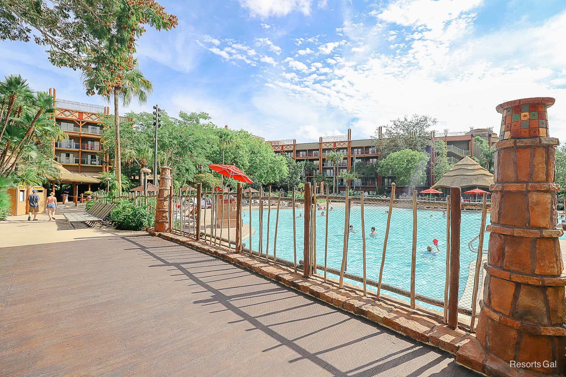 a fenced off bridge with decorative columns by the pool 