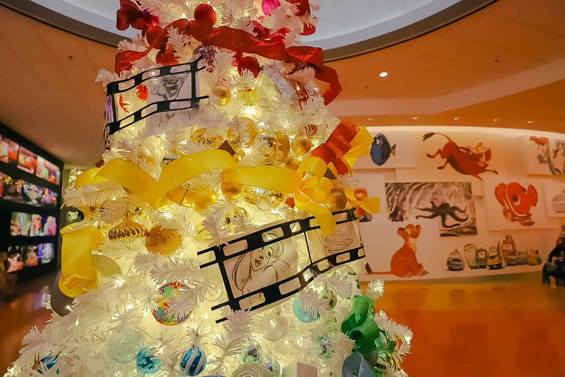 Art of Animation white Christmas tree wrapped in layers of primary colors. 