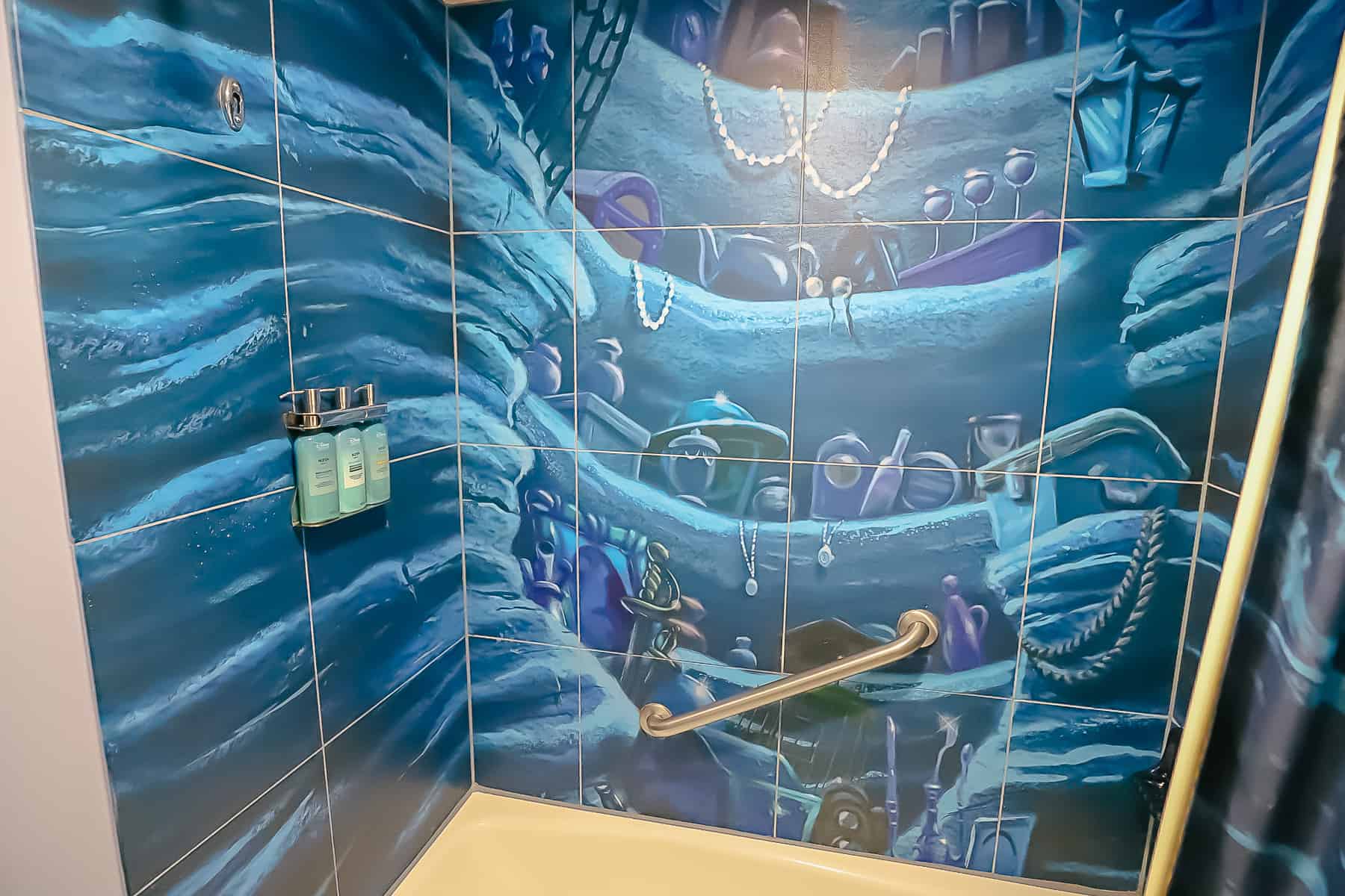 the shower tiles are painted like a mural of Ariel's treasure trove 