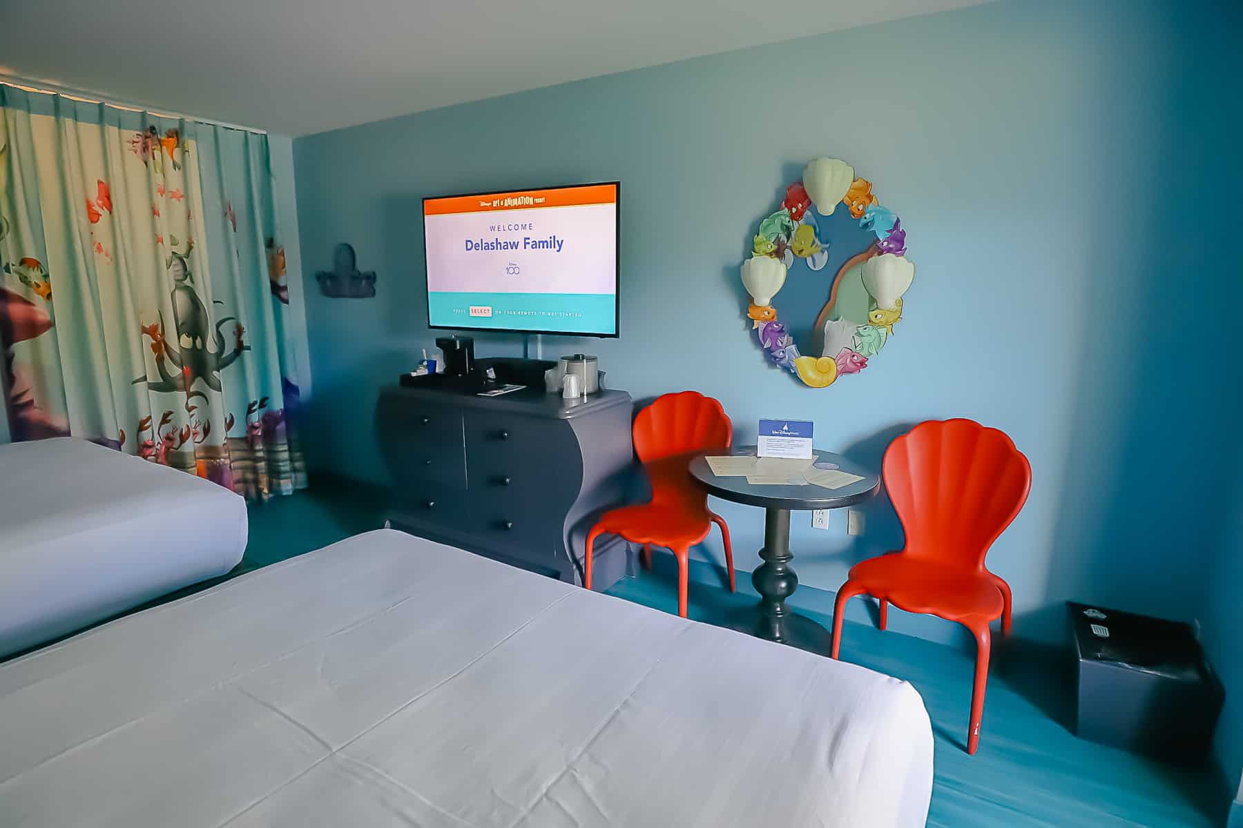 Feature wall has table, chairs, decorative mirror, dresser, and television