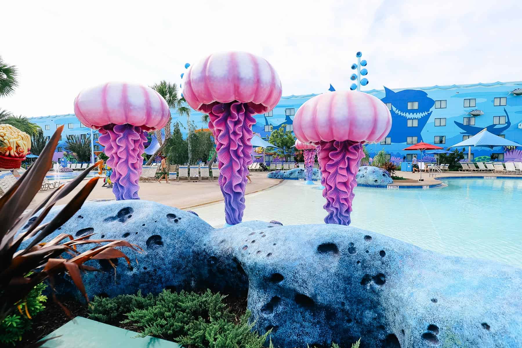 Side of the pool with landscaping and rock formations at Art of Animation. 