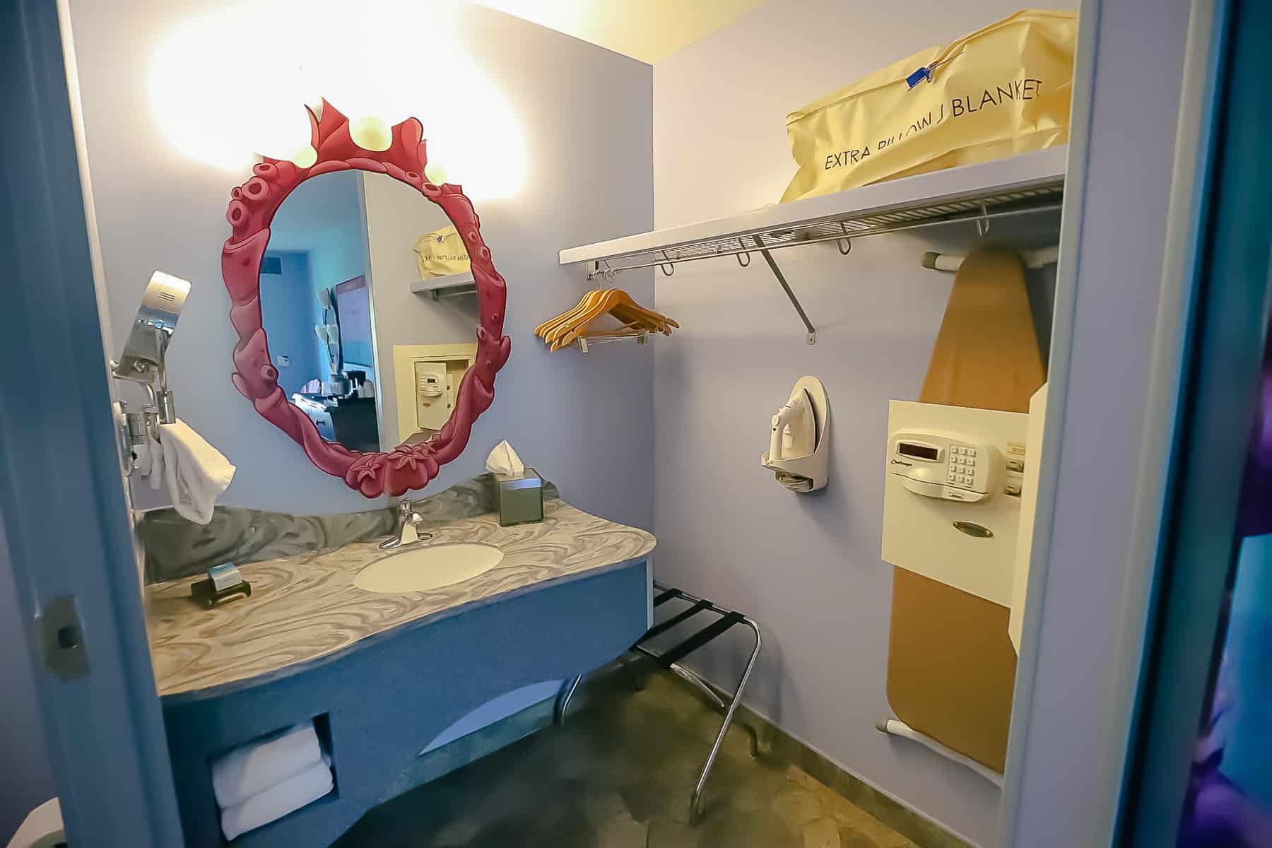 The bathroom area features a vanity with one sink, a mirror, and an open closet space. 