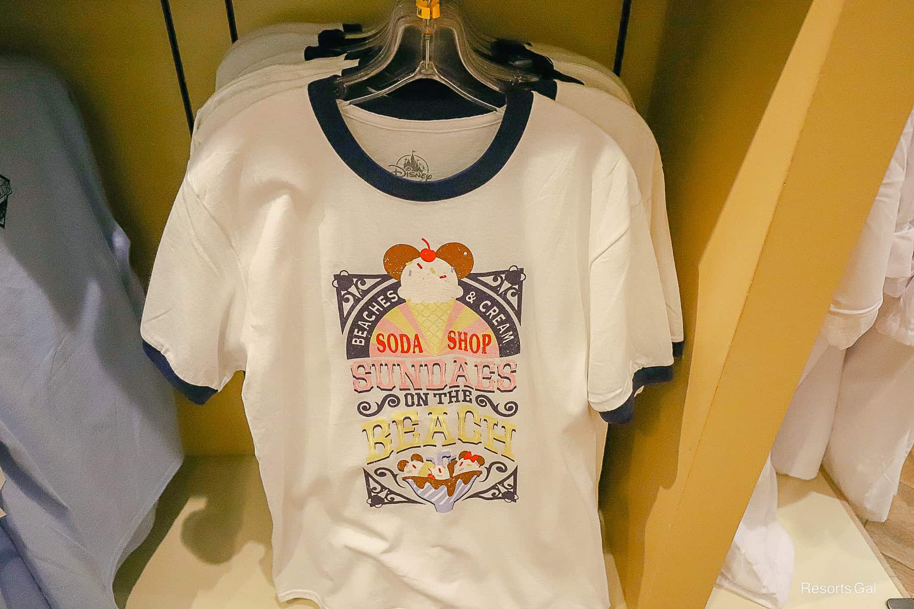 a t-shirt with navy blue sleeve and neck trim featuring ice cream treats from Beaches and Cream