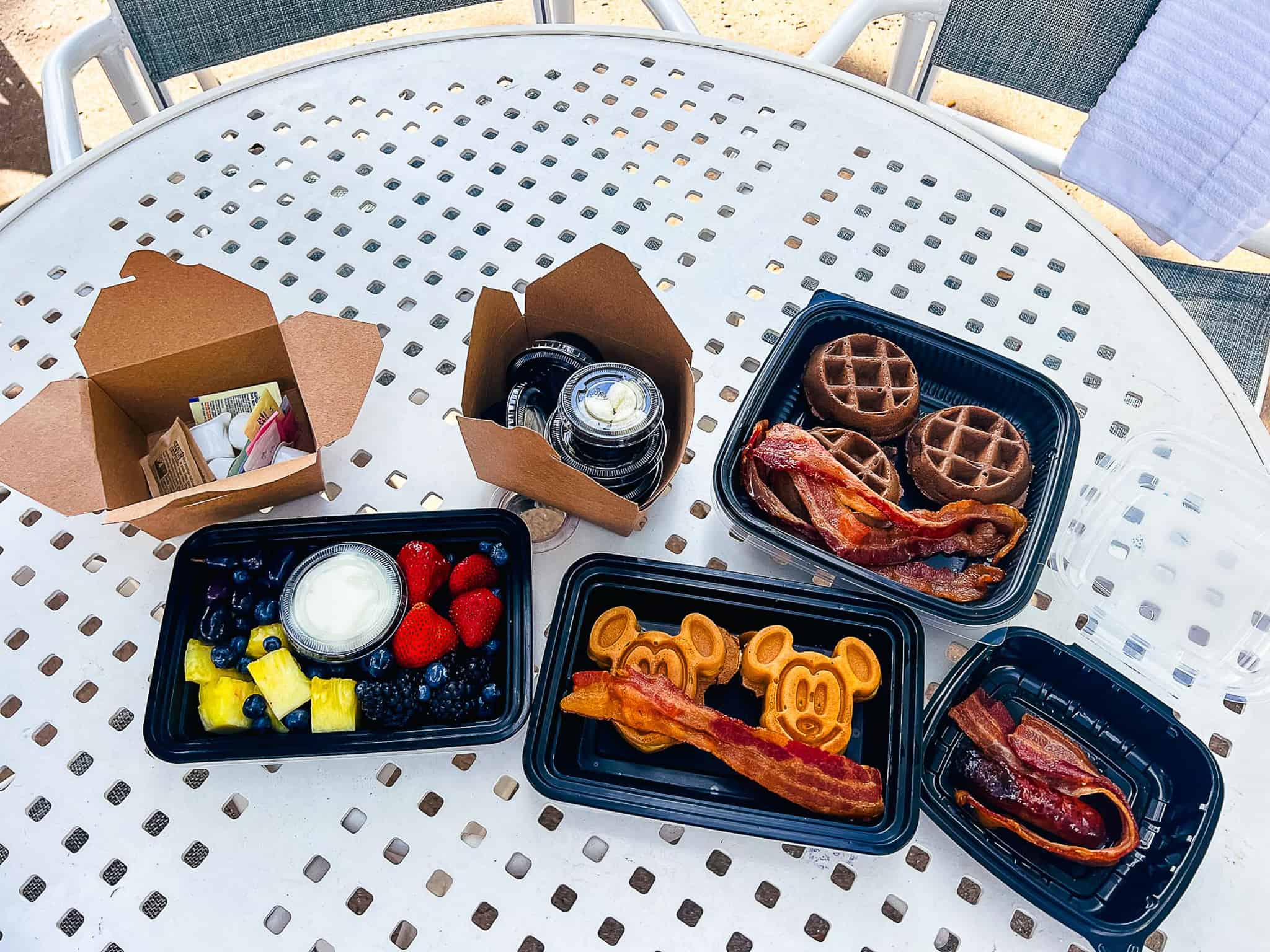 a sample of breakfast items from Disney's Beach Club with a fruit tray, chocolate waffles, bacon, and Mickey waffles