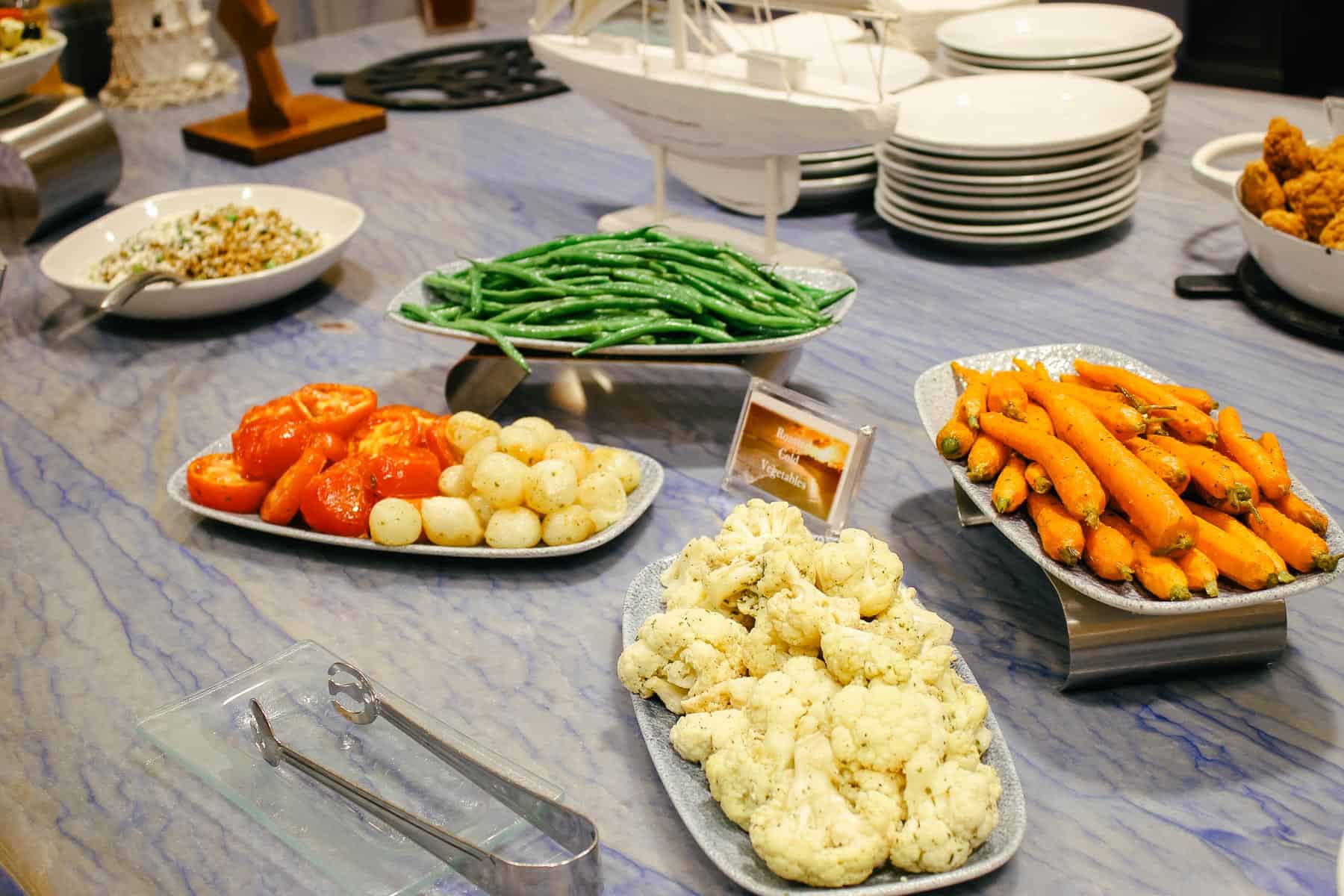 trays with green beans, tomatoes, cauliflower, and carrots 