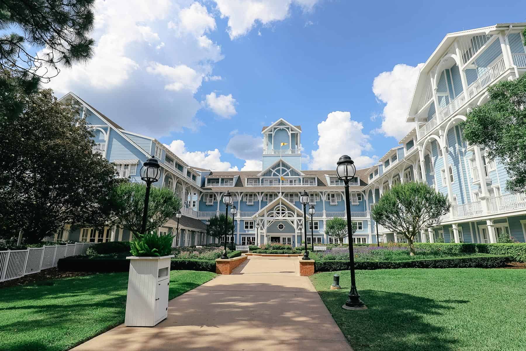 the resort side entrance of Disney's Beach Club with blue siding, white trim, and yellow flags