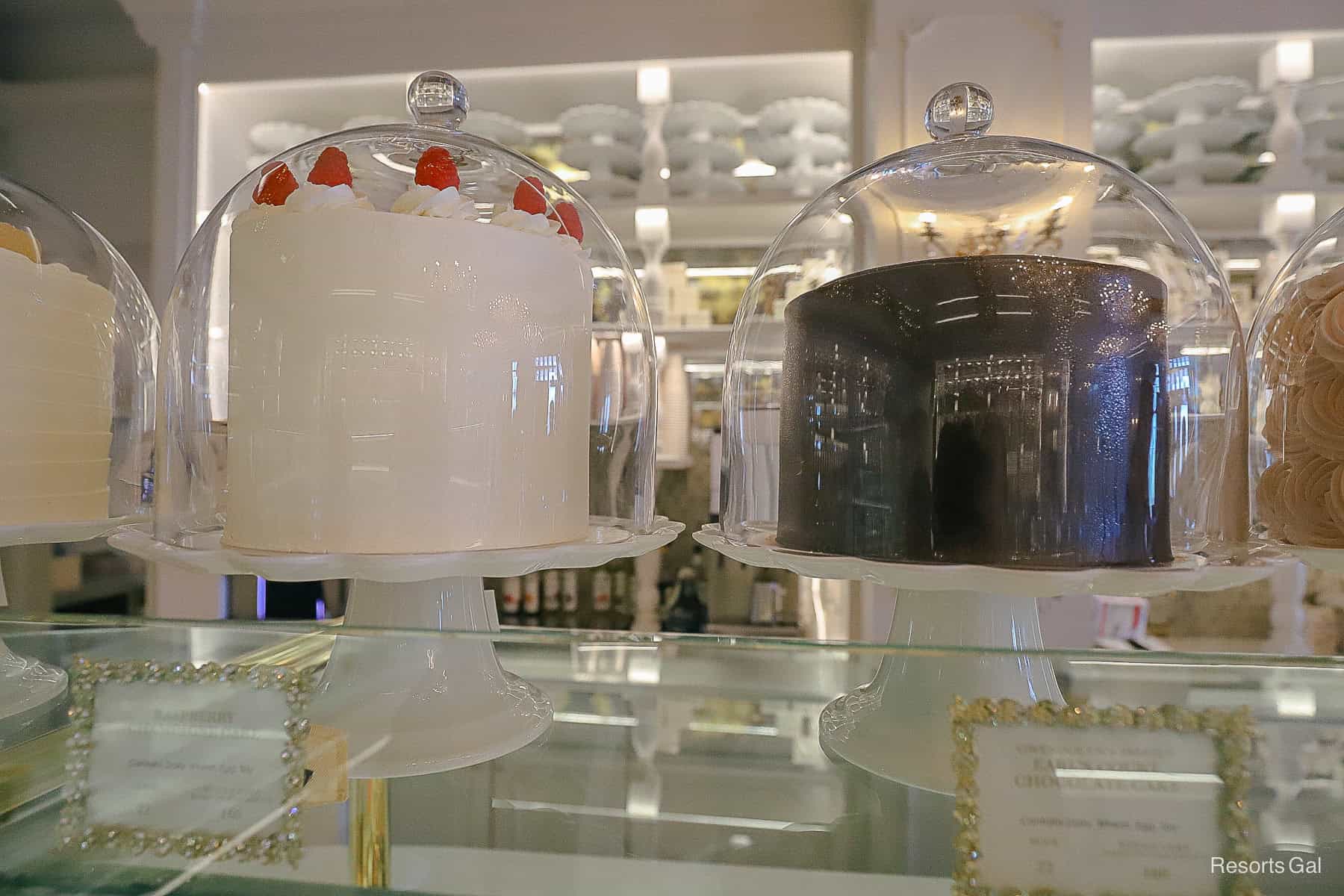 two cakes in glass domes sitting inside the Cake Bake Shop at Disney's BoardWalk