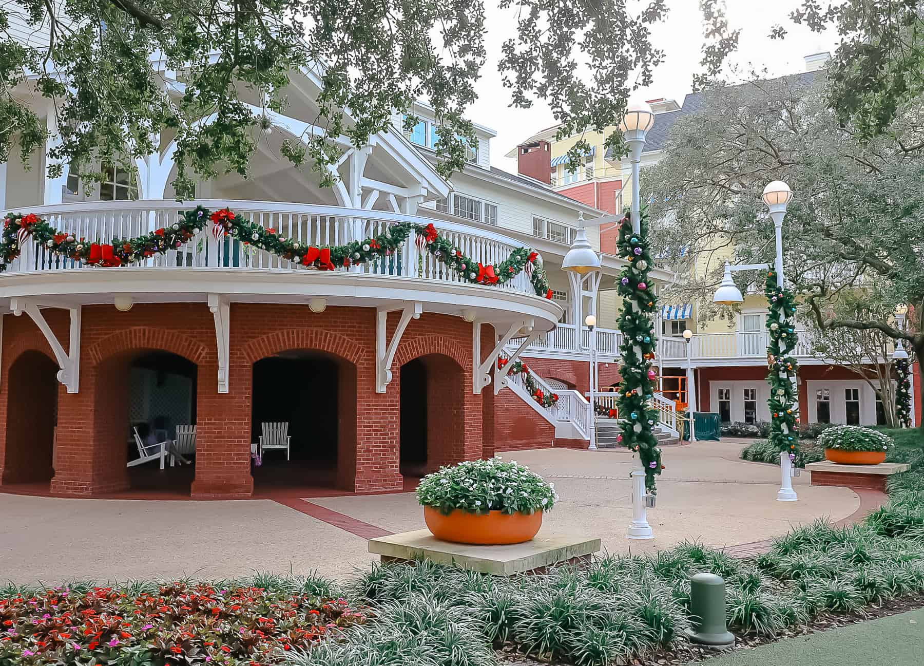 the upper and lower patios at Disney's Boardwalk Inn decorated for Christmas 