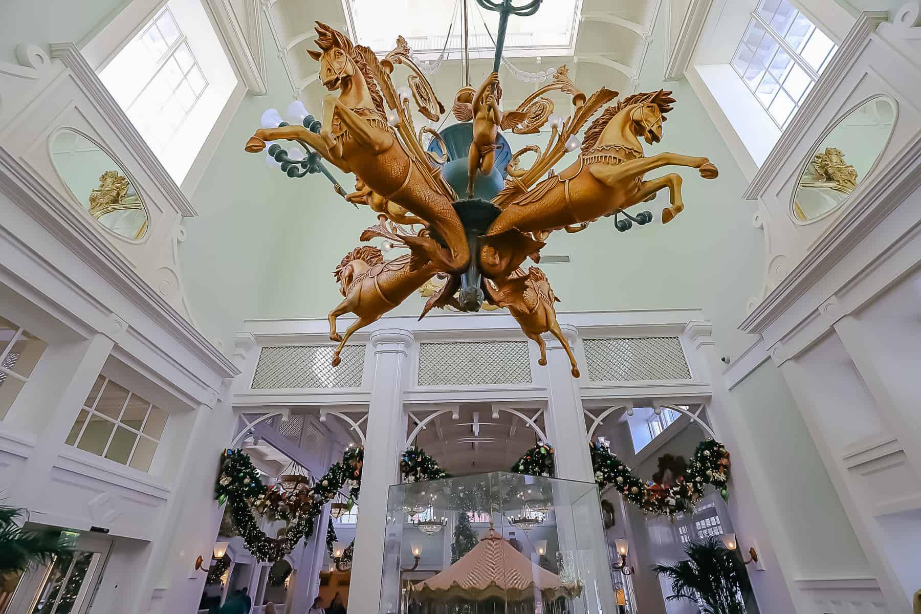 a chandelier in the foyer of Disney's Boardwalk with garland draped in the background 