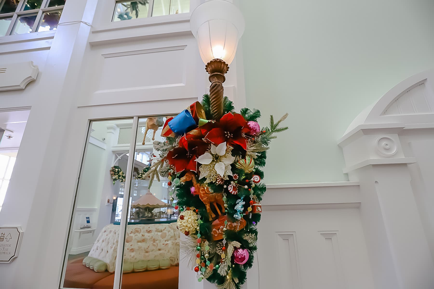 a light sconce draped with Christmas decorations 