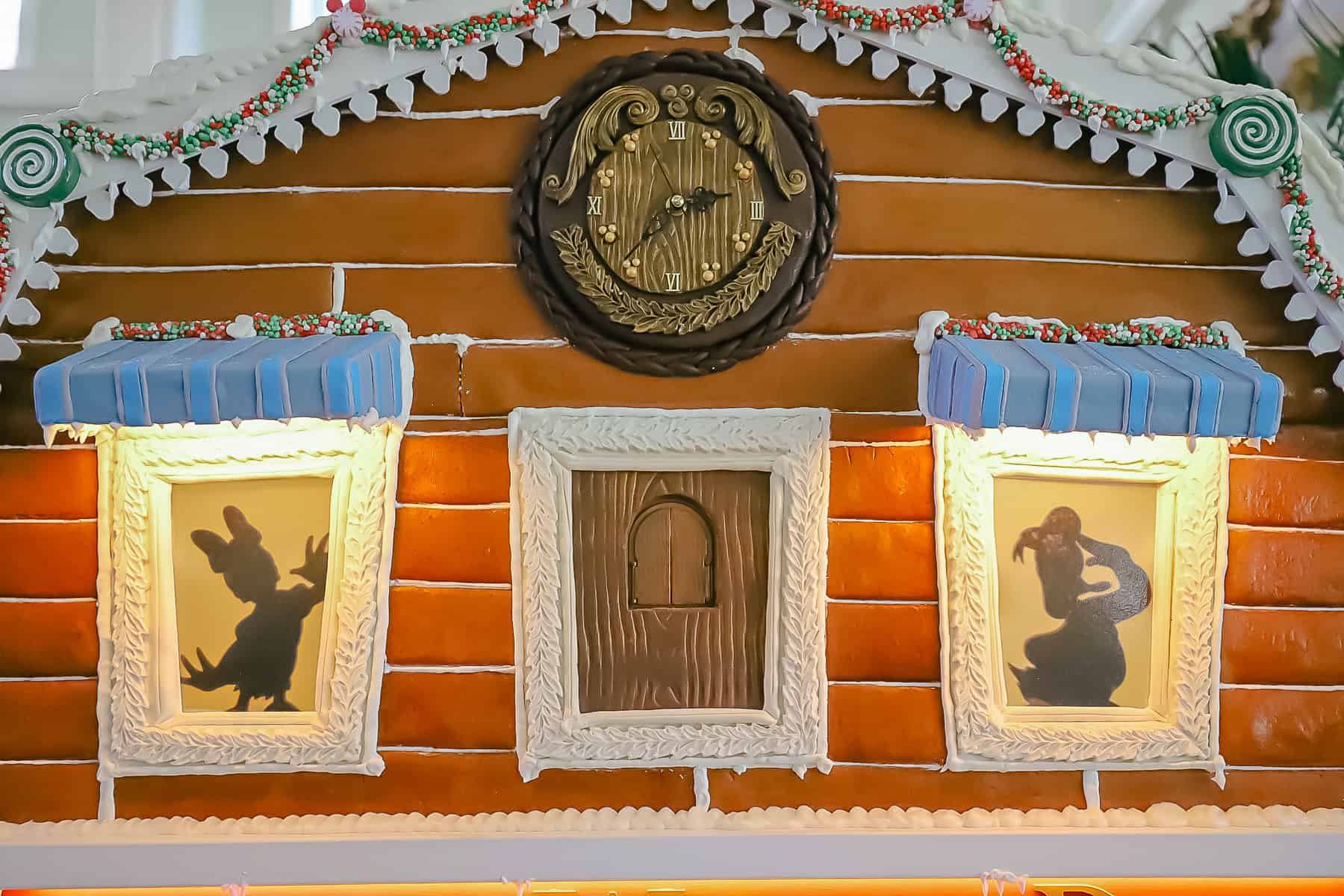 Silhouettes of Donald and Daisy Duck in the top floor of Disney's Boardwalk gingerbread house