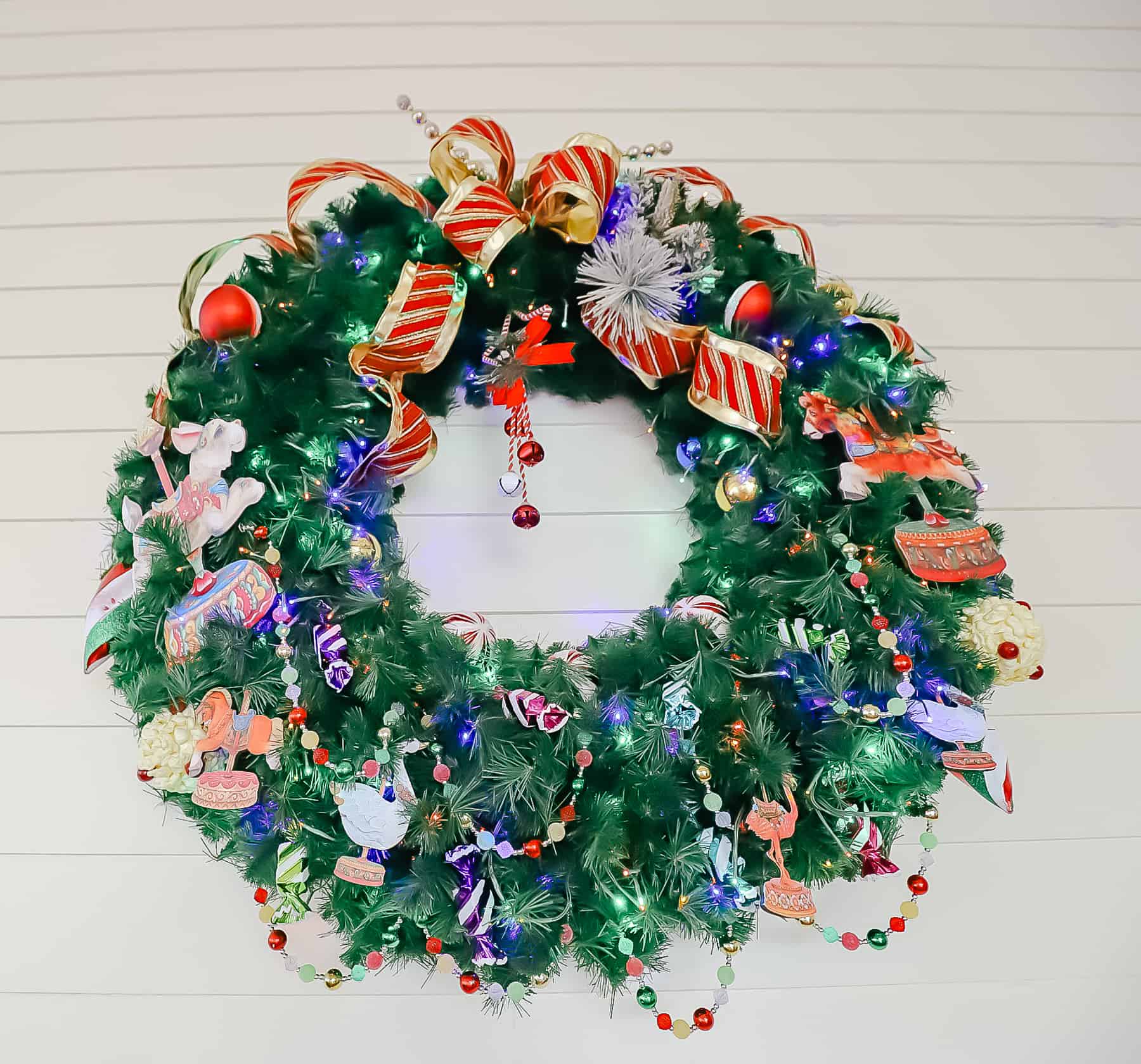 an outdoor wreath with bright red, gold, and blue decorations at Disney's Boardwalk 