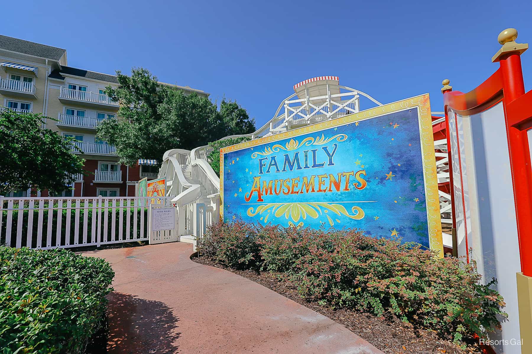 a blue sign that says Family Amusements in front of the pool slide 