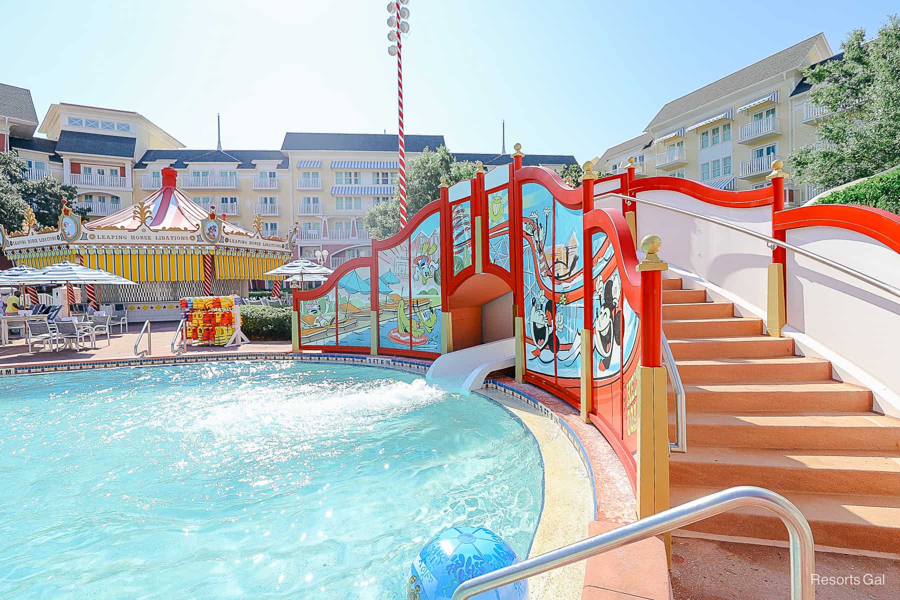 a blue ball floating on top of the pool water near the waterslide exit 