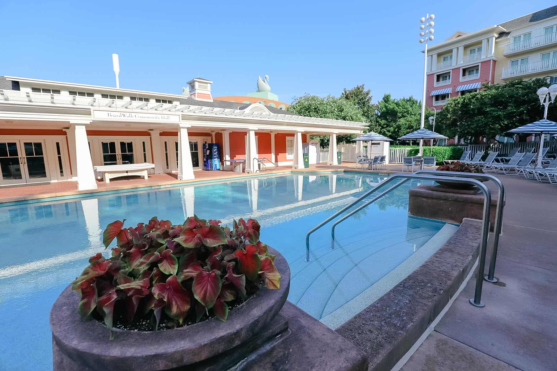 pool steps leading down to the water with potted plants on each side 