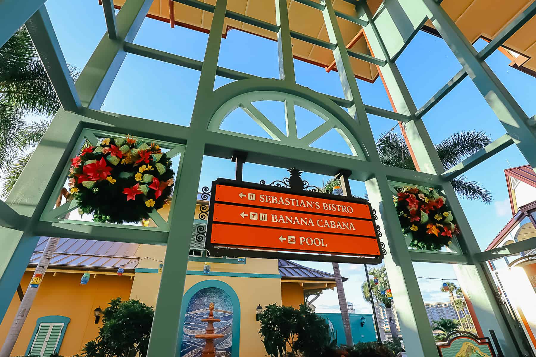 Signage that's flanked by two Christmas wreaths. 