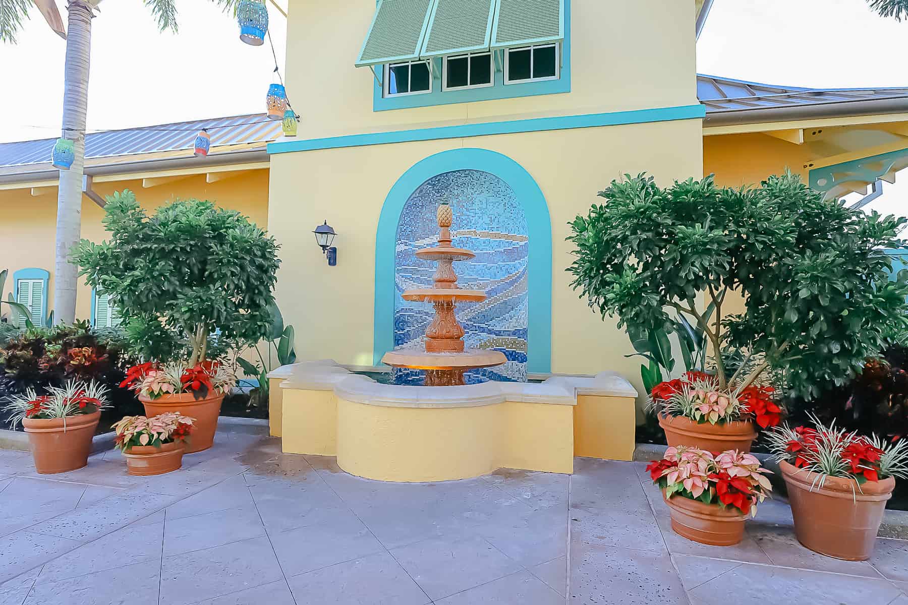 The fountain near the resort entrance surrounded with potted poinsettias. 