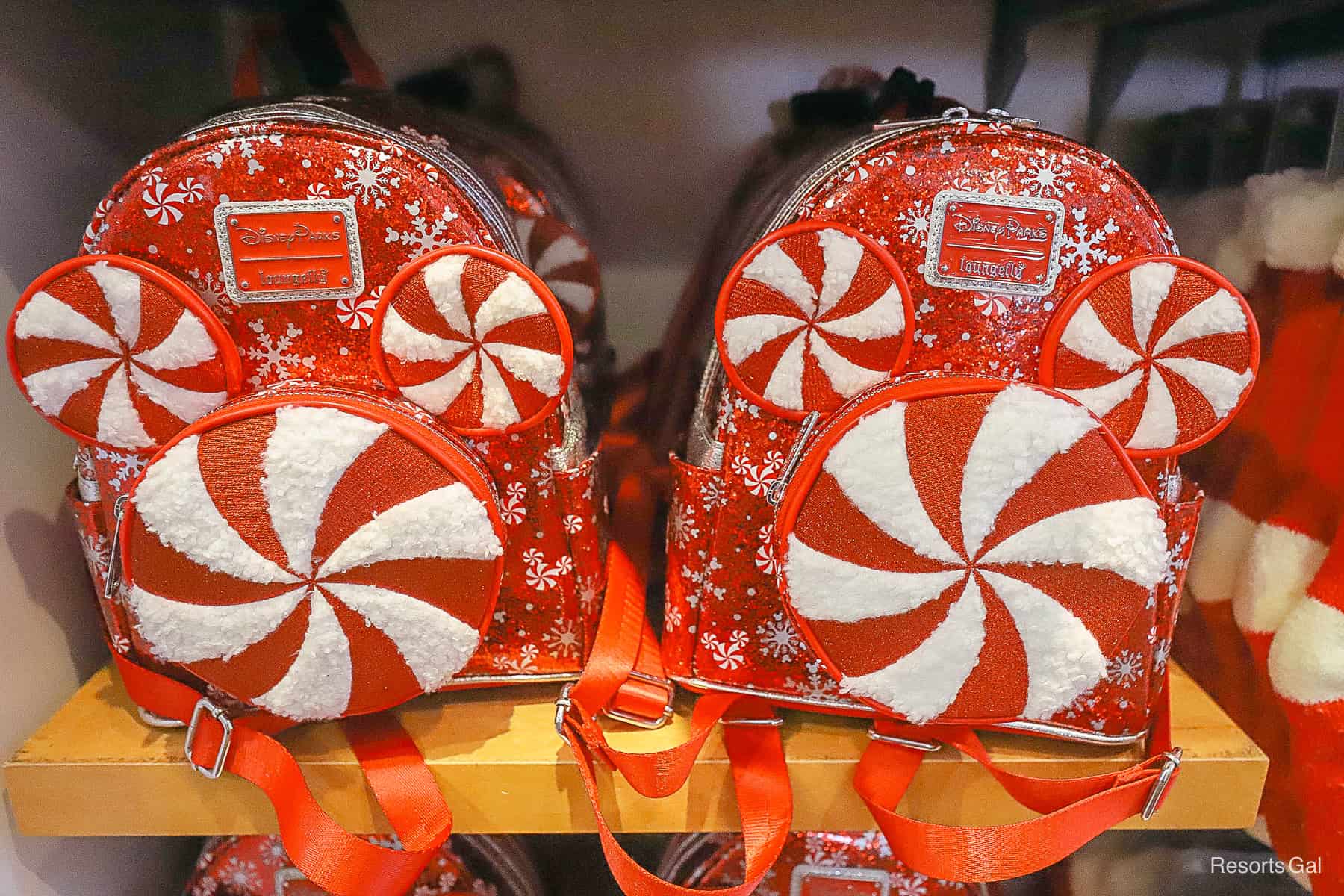 a Disney Parks Loungefly in red with silver snowflakes and a soft peppermint Mickey on the front 