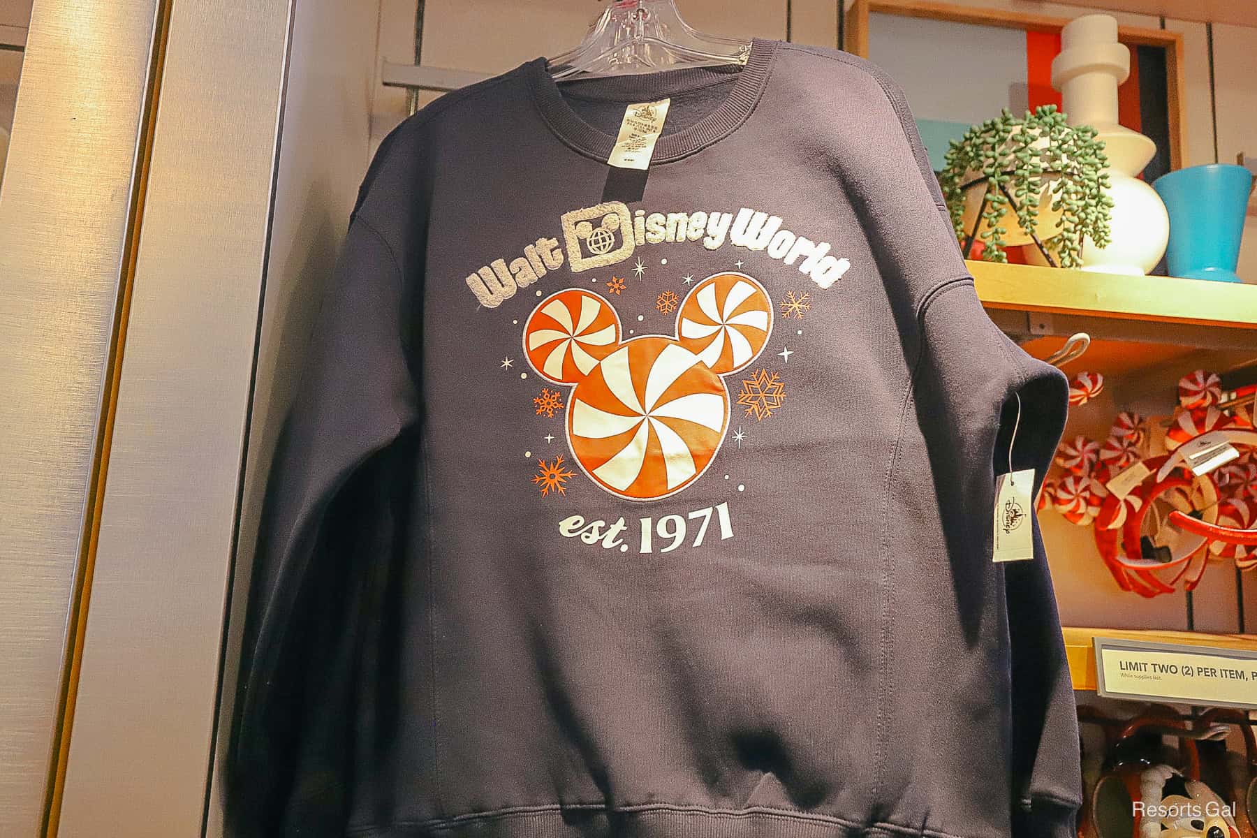 a navy sweatshirt that says Walt Disney World est. 1971 with a peppermint in the middle