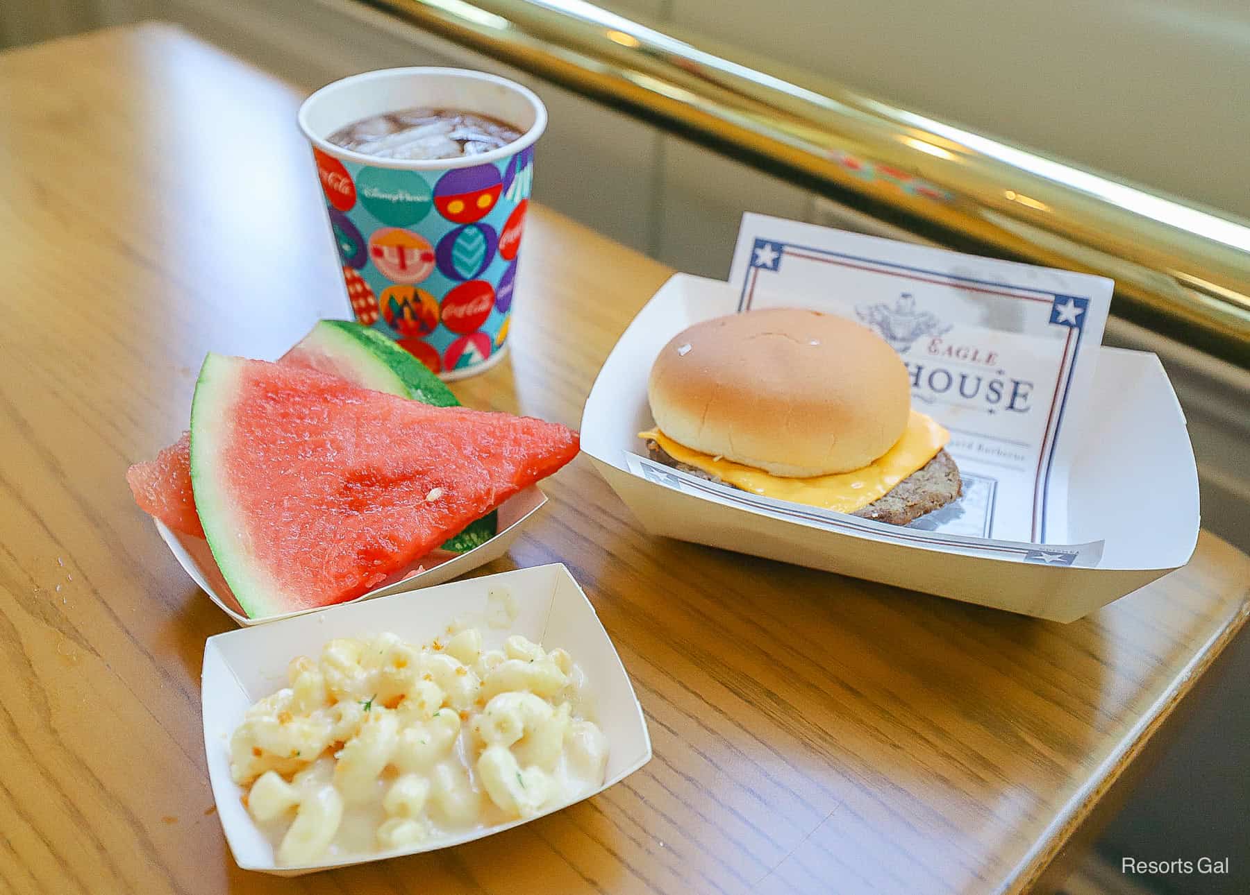a kids' meal with a small soda, watermelon slices, macaroni and cheese, and a cheeseburger