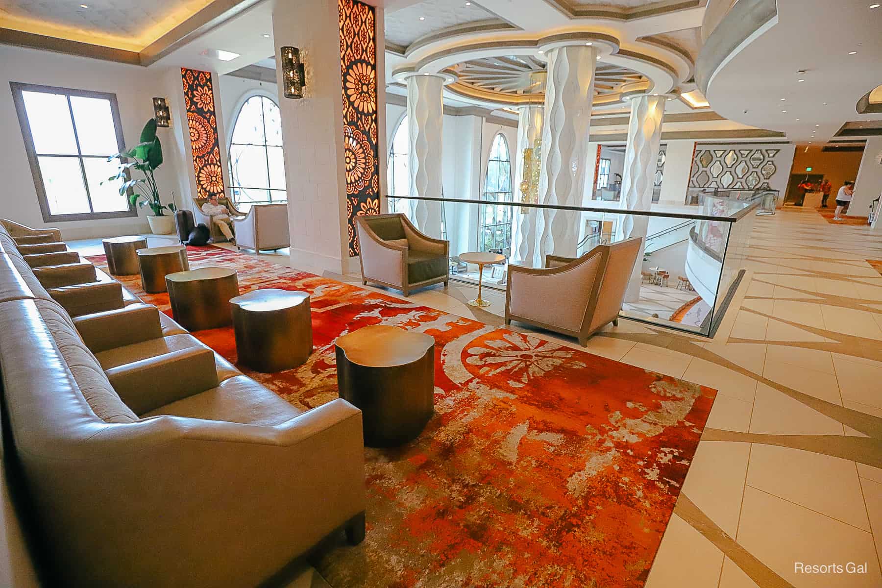 a low row of individual leather seats on a bright red rug off the lobby of Gran Destino Tower 