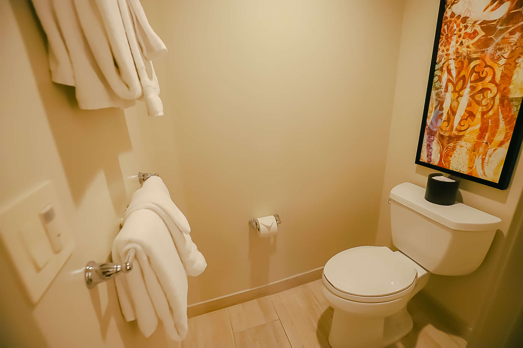 the water closet with towel rack and toilet 