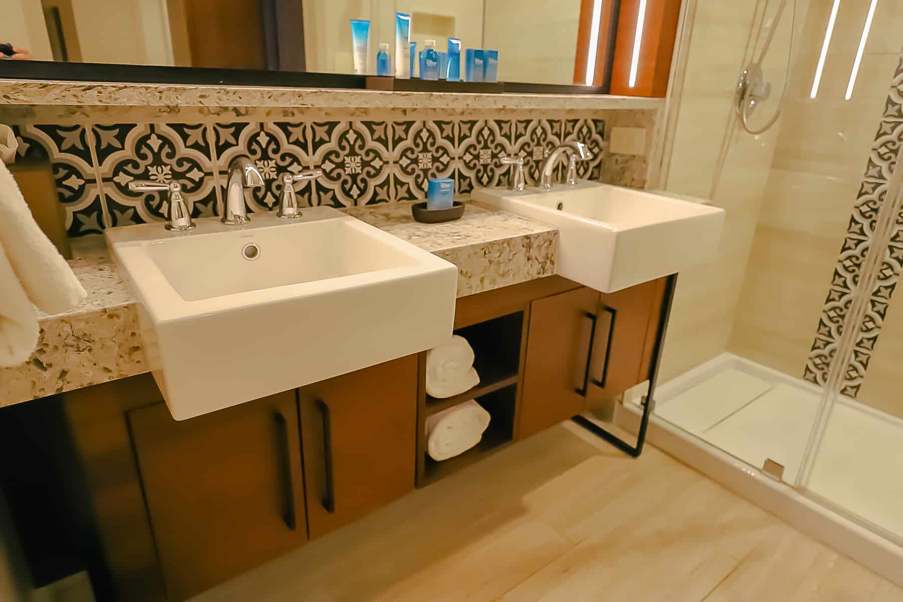 shows the two square sinks with cabinets for storage underneath in the bathroom 
