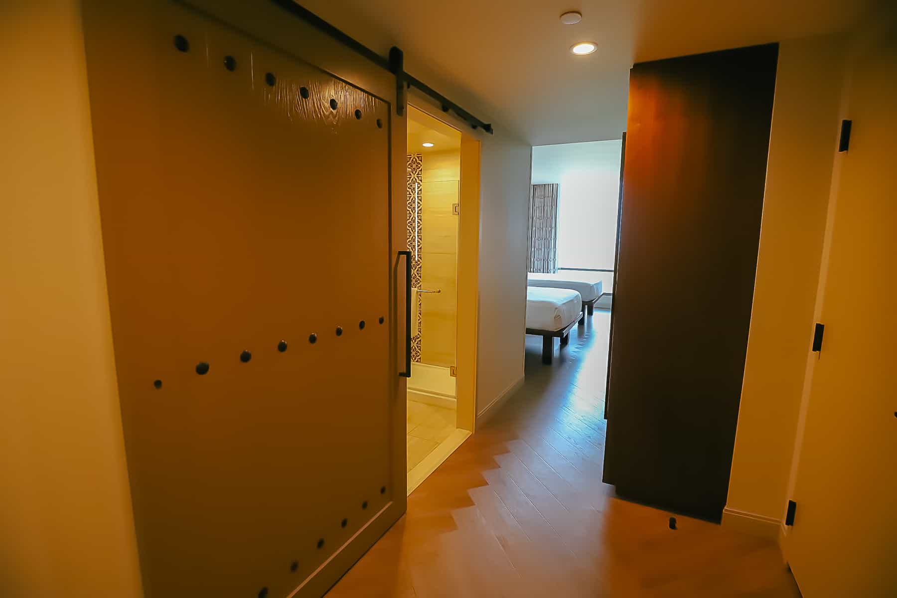 Foyer of the room with a large sliding door that covers the guest bathroom. 