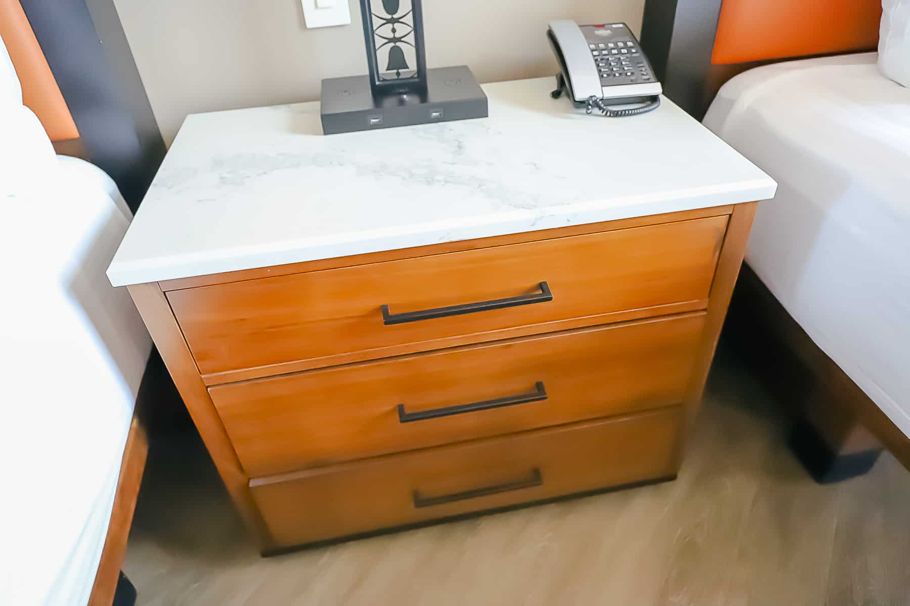 A nightstand that has three drawers. 