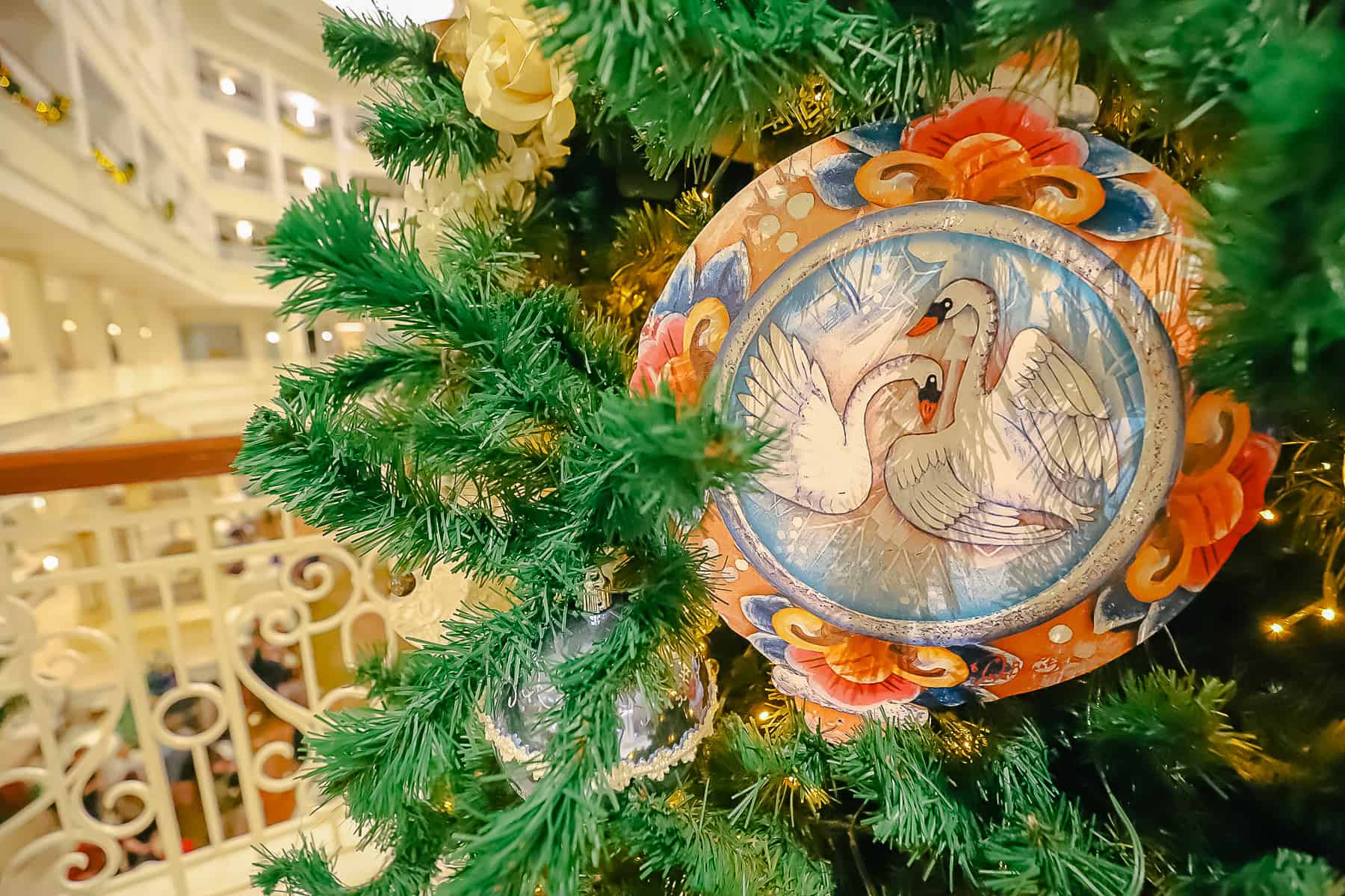 A medallion ornament with a pair of swans. One appears to be sheltering the other.