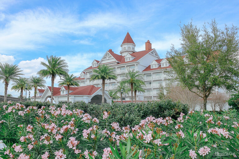The Grand Floridian Villas with pink flowers in bloom surrounding it.