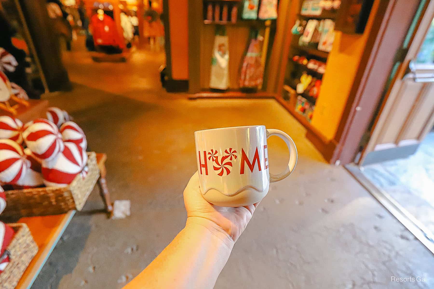a coffee mug with "Home" printed in red and peppermint Mickey design