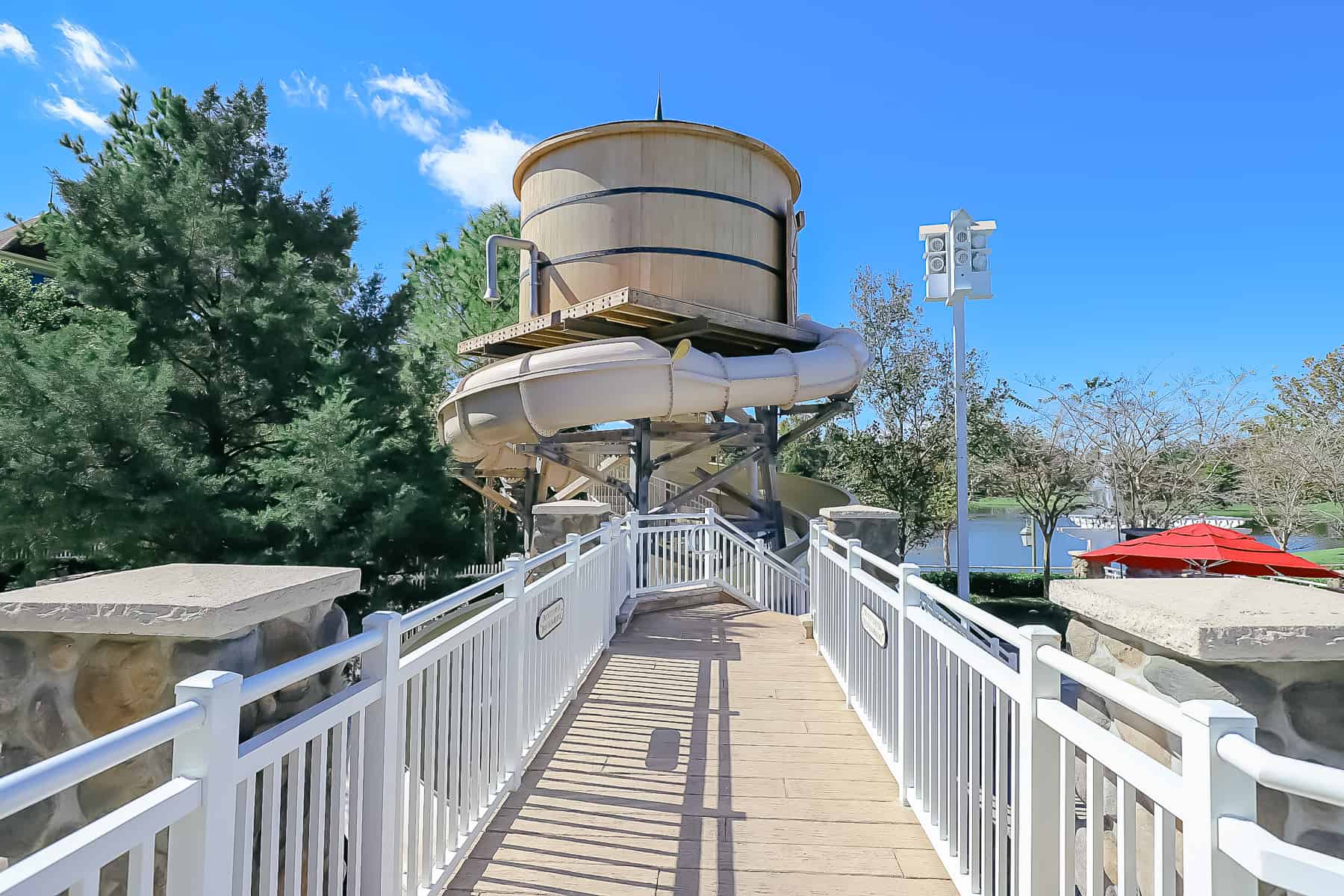a bridge over a pool that leads to a water slide that looks like a water tower 