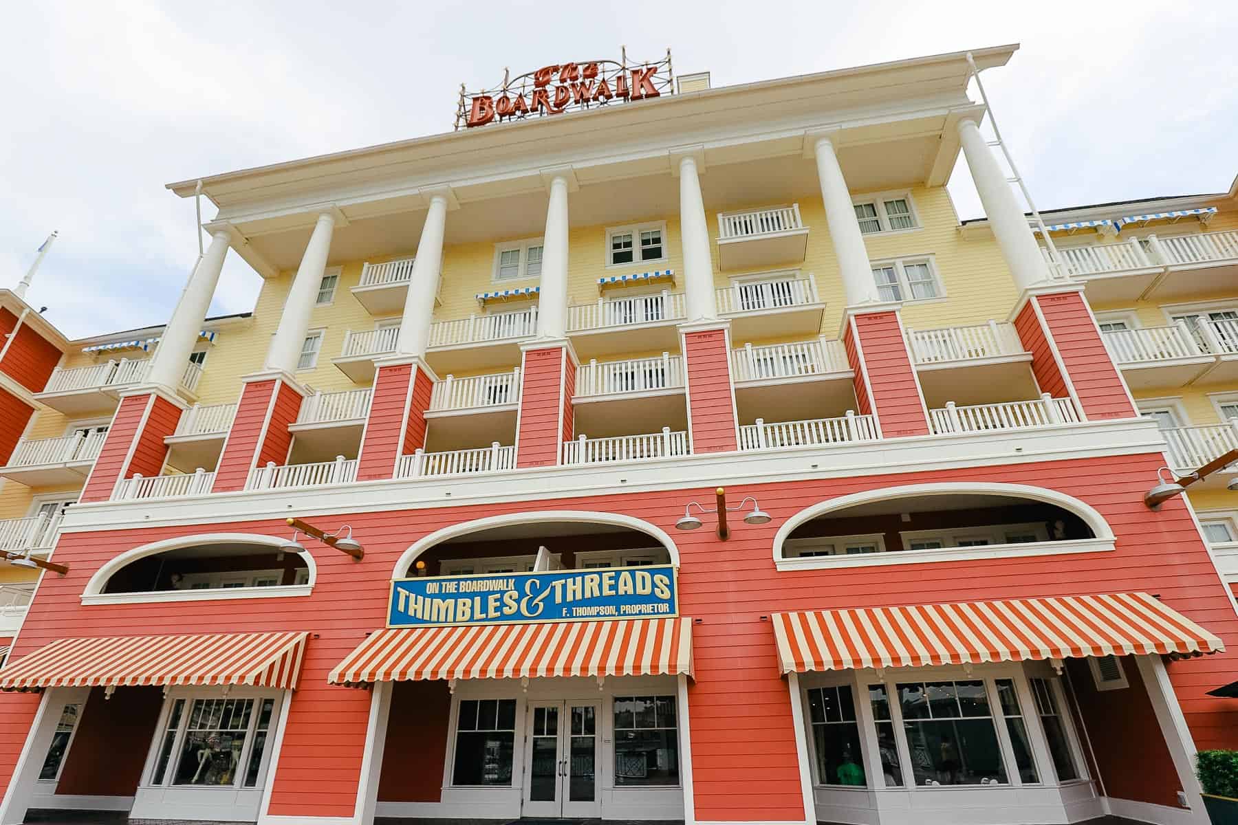 The exterior of Disney's Boardwalk with bright red and yellows and the Boardwalk sign. 