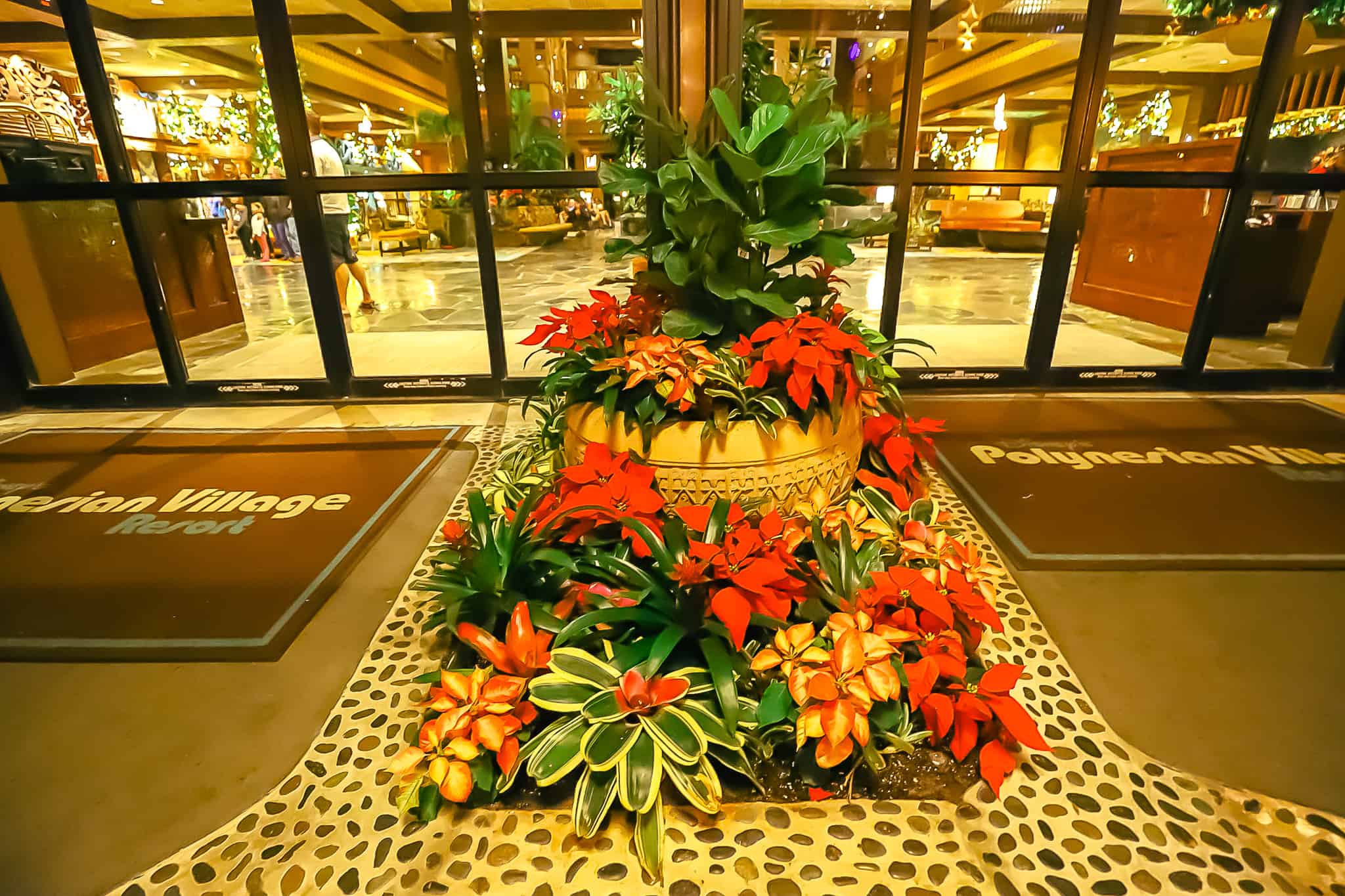 A large display of potted plants has poinsettias in various colors added for Christmas. 