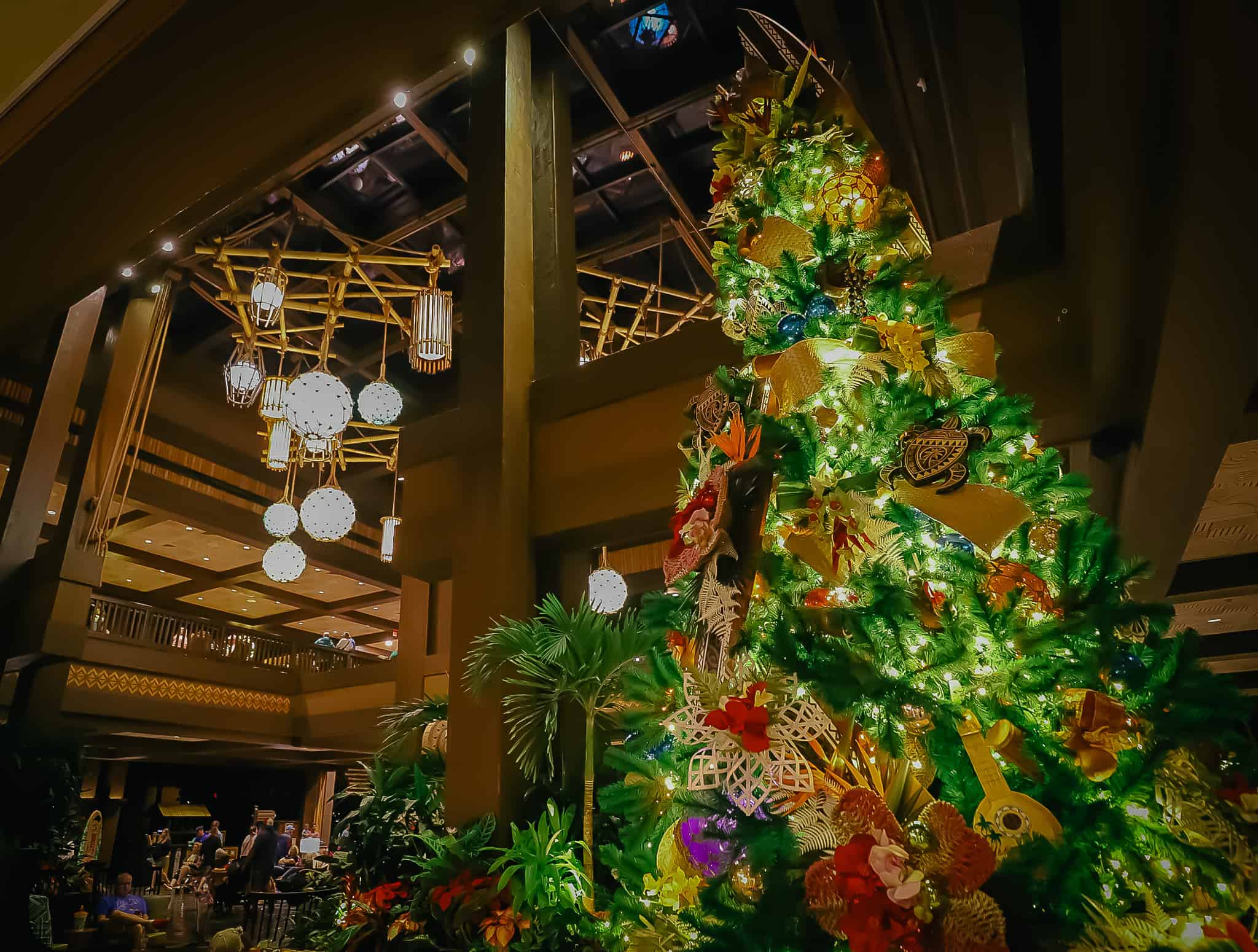Polynesian's tropical Christmas tree with the famous lobby light fixture beside it. 