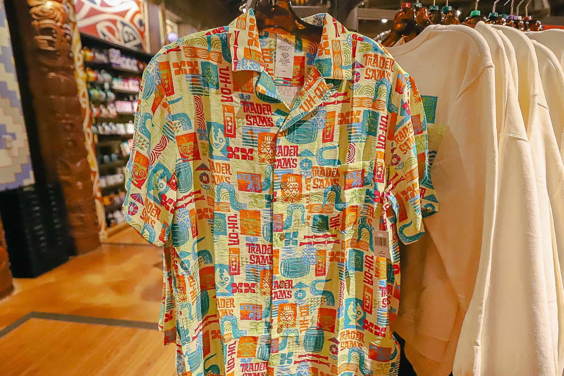 a button up shirt with collar and an all over Trader Sam's print in yellows, oranges, and blues