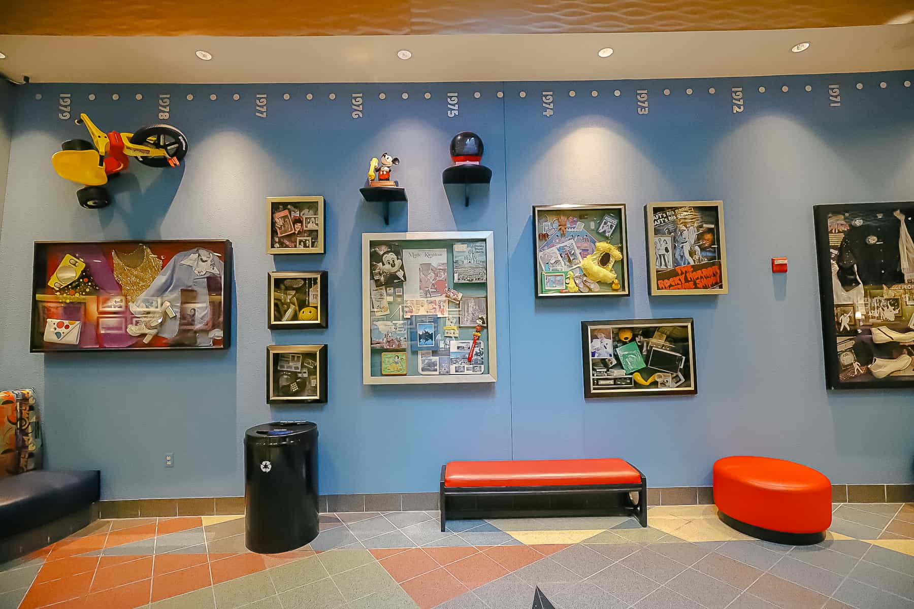 A wall off the lobby of Pop Century has displays of items from each decade represented at the resort. 