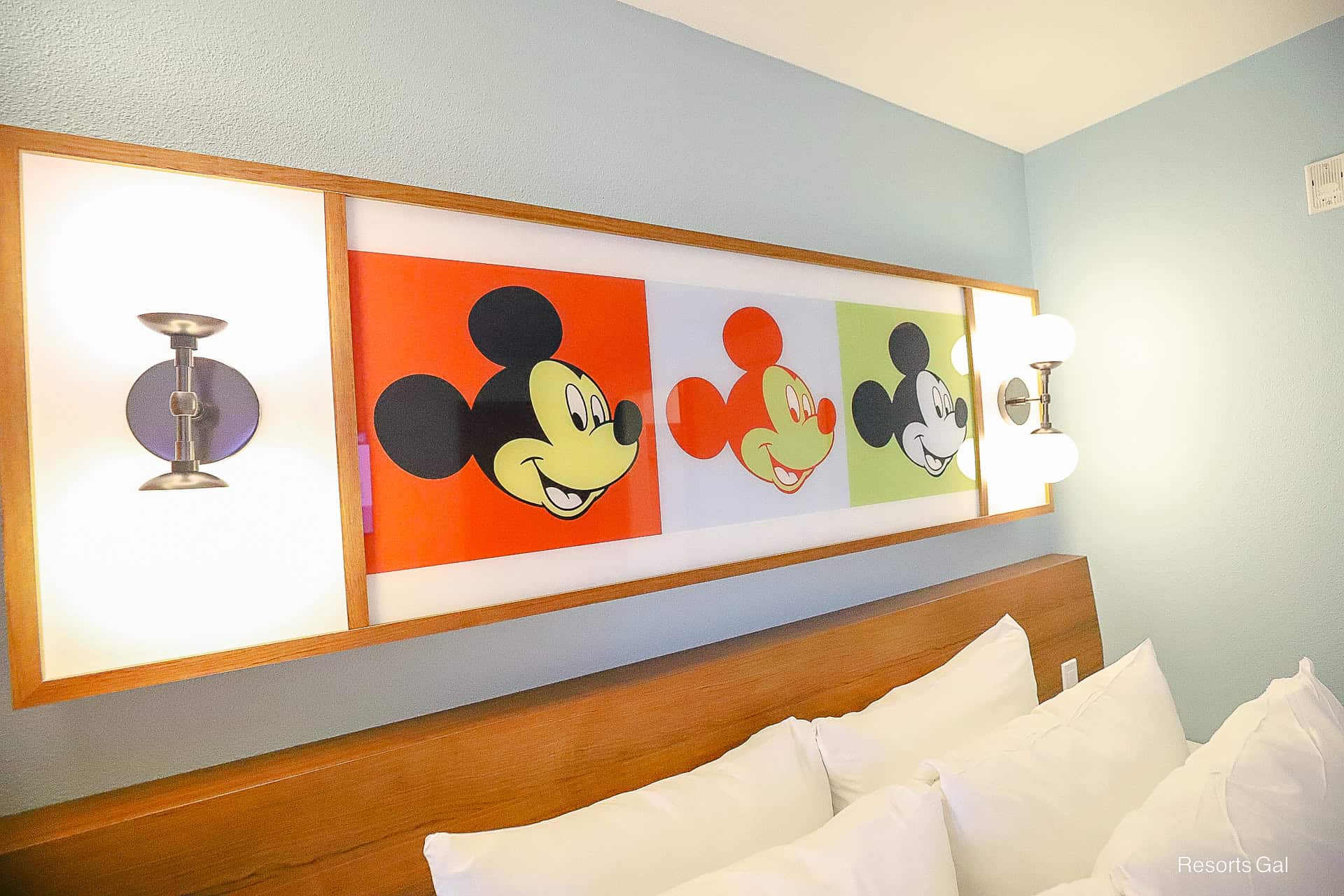 a piece of artwork with three Mickey Mouse's and light fixtures on each end 