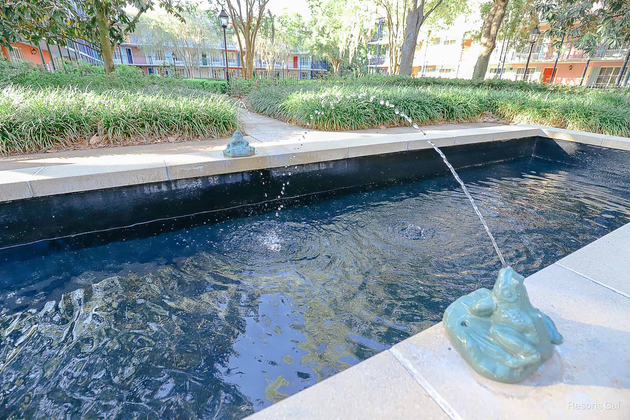a fountain that has ceramic frogs spitting water 