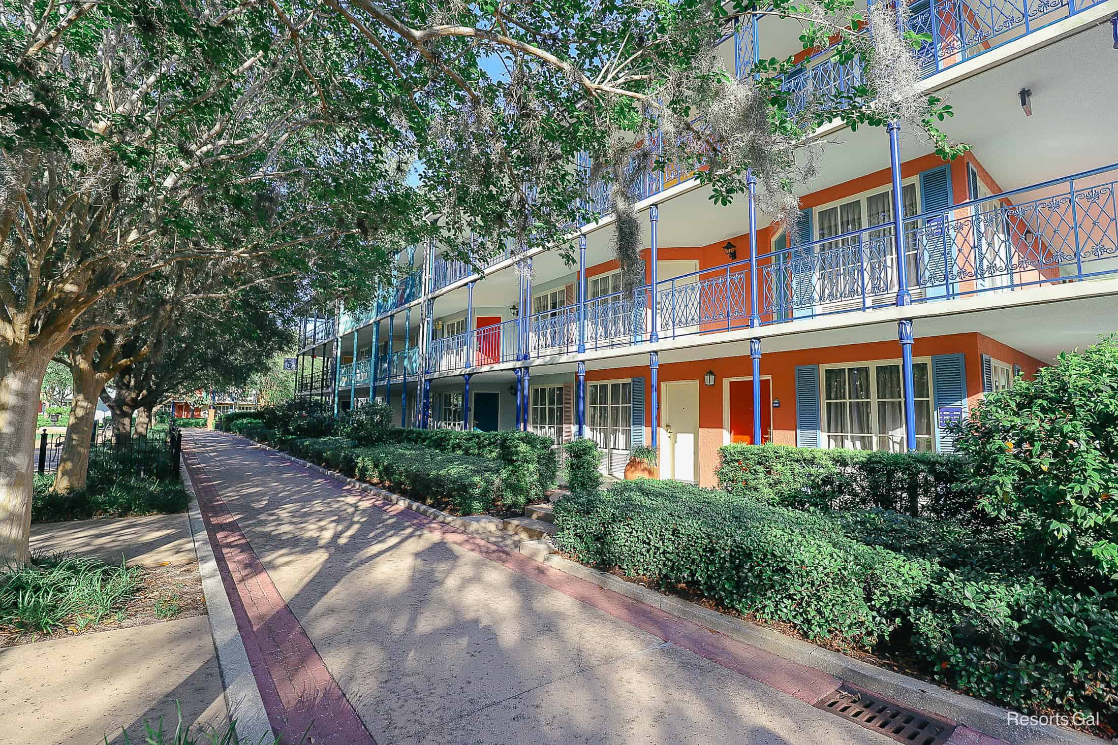 a row of bright buildings with corals, greens, blues and reds 